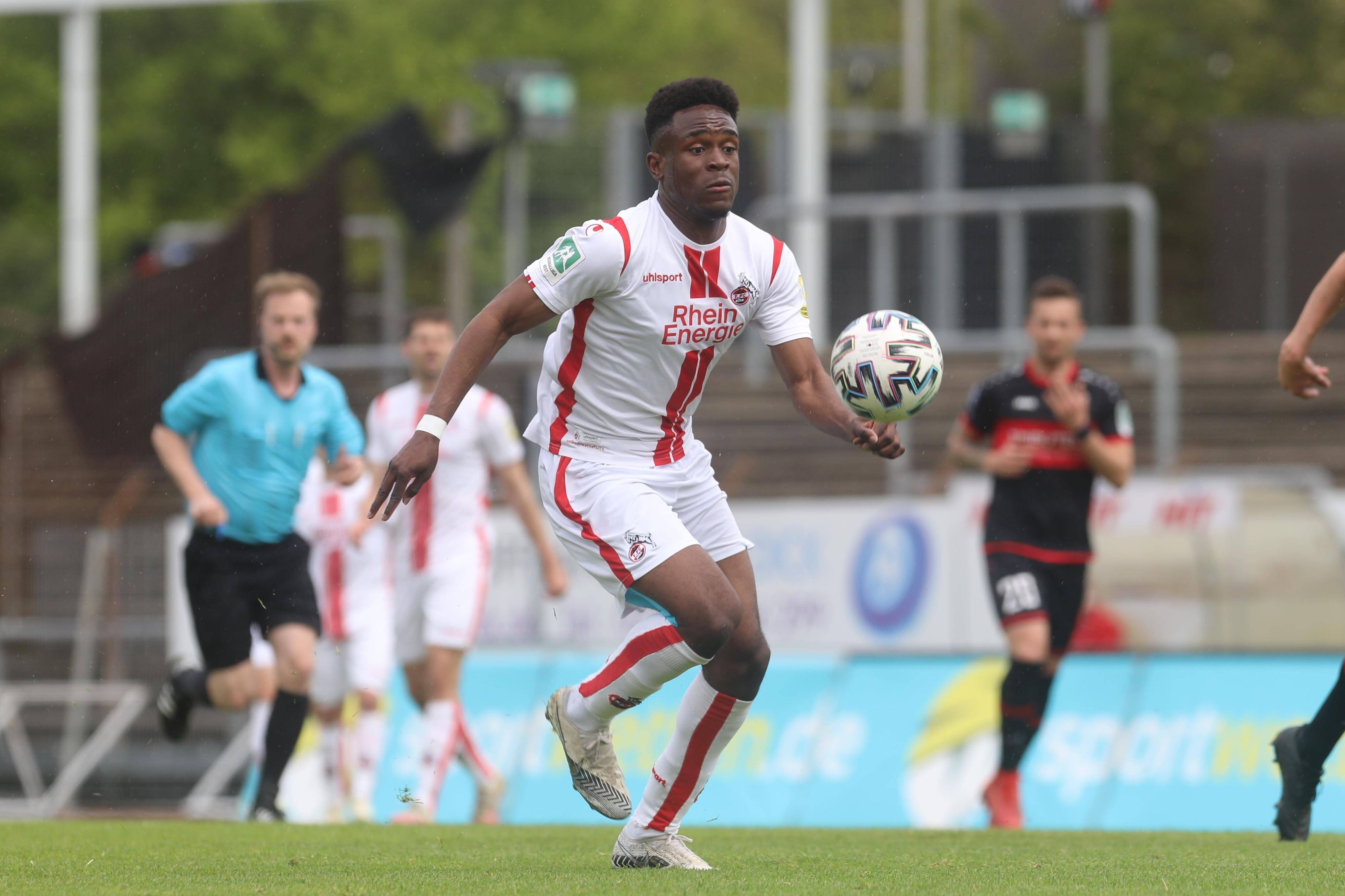 Das Foto zeigt Noel Futeku am 8. Mai 2021 im Regionalliga-Spiel des 1. FC Köln gegen den FC Wegberg-Beeck. Der Angreifer schaut energisch auf den Ball.