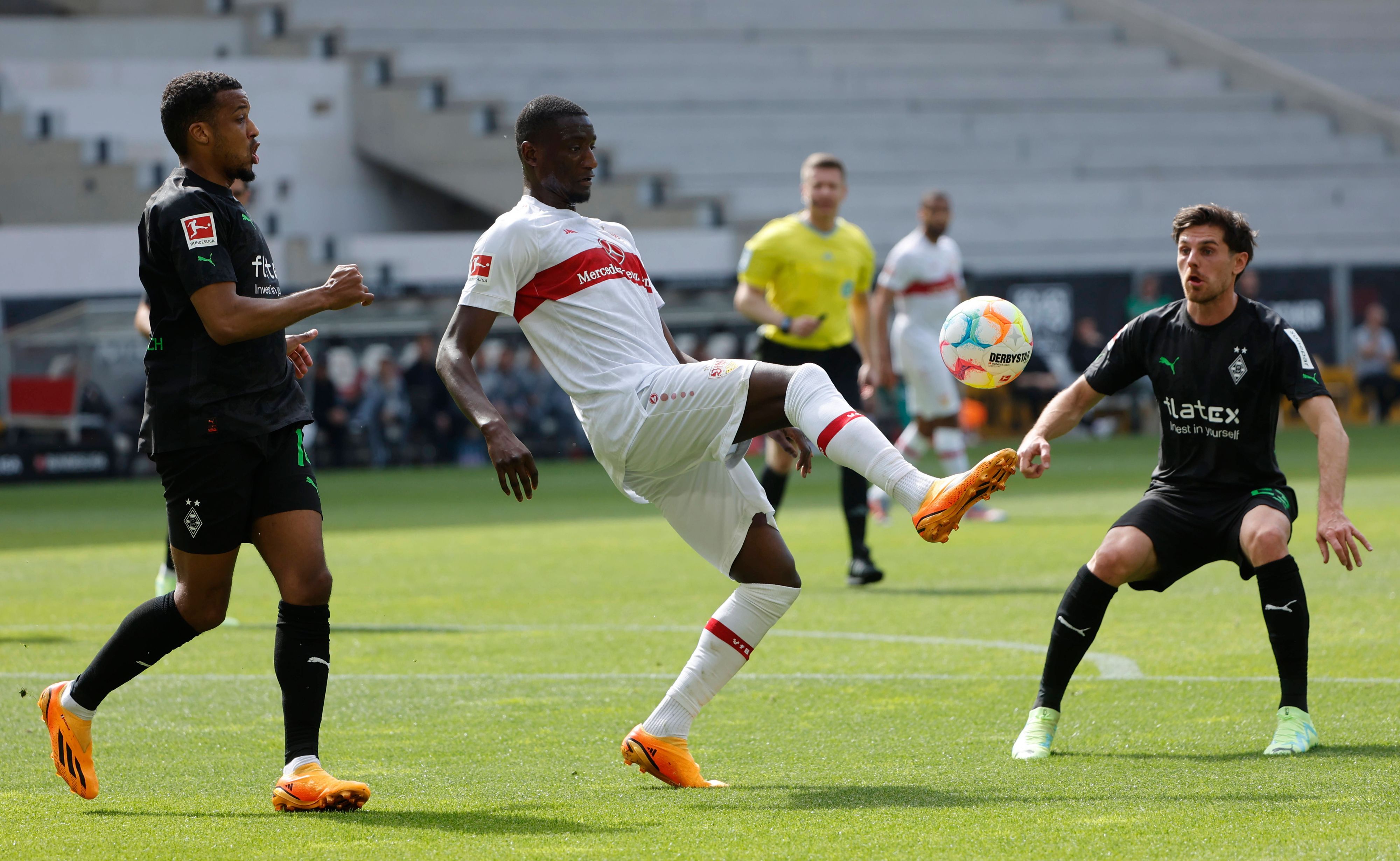 Die Gladbach-Profis Alassane Plea (l.) und Jonas Hofmann (r.) während der Bundesliga-Partie am Samstag (29. April 2023) beim VfB Stuttgart im Duell mit Serhou Yadaly Guirassy (M.). Der Stuttgarter behauptet den Ball.