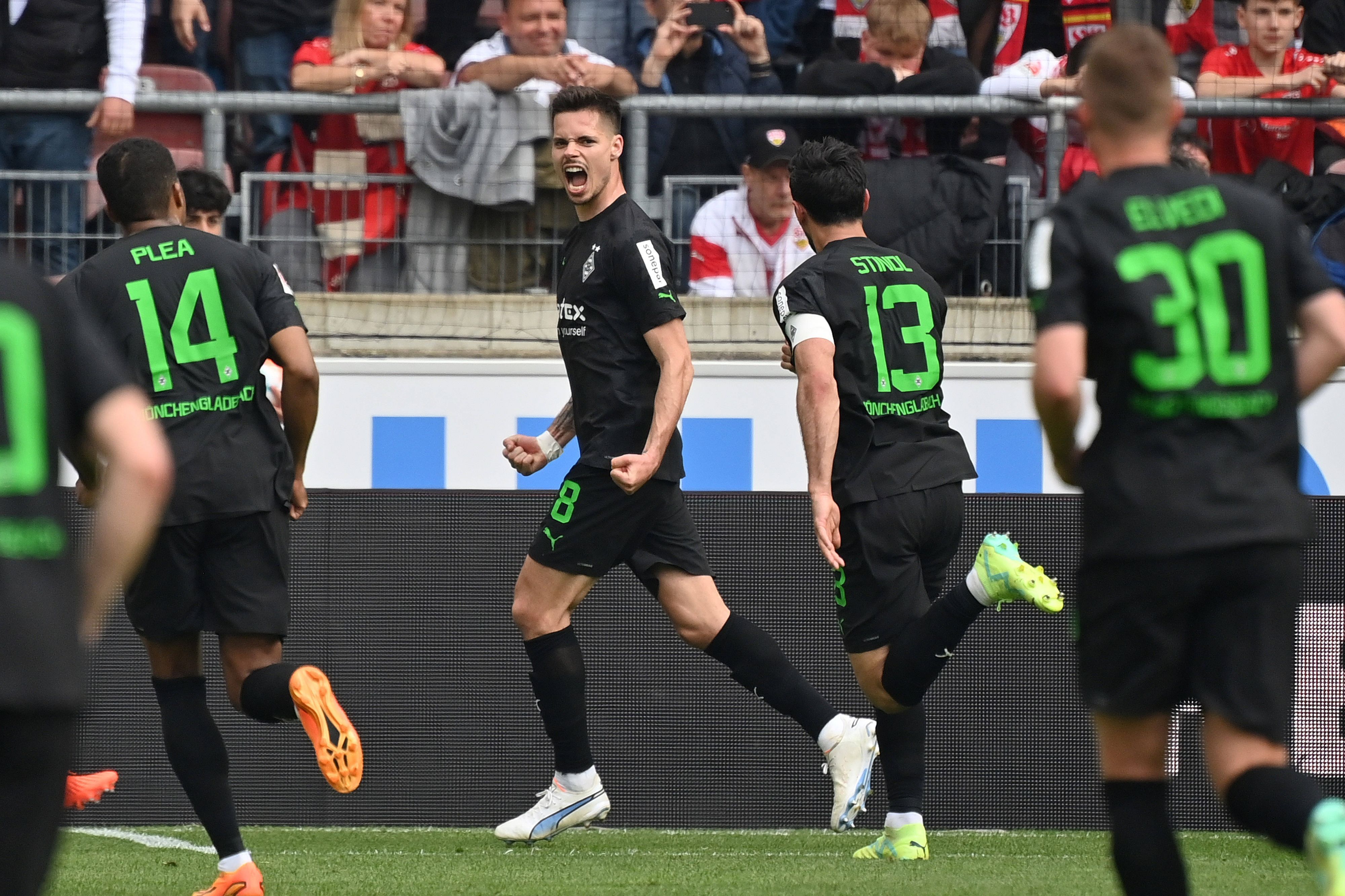 Julian Weigl (M.) jubelt nach seinem verwandelten Elfmeter für Borussia Mönchengladbach zum zwischenzeitlichen 1:1 beim VfB Stuttgart am 29. April 2023. Lars Stindl und Alassane Plea eilen zum Jubel herbei.