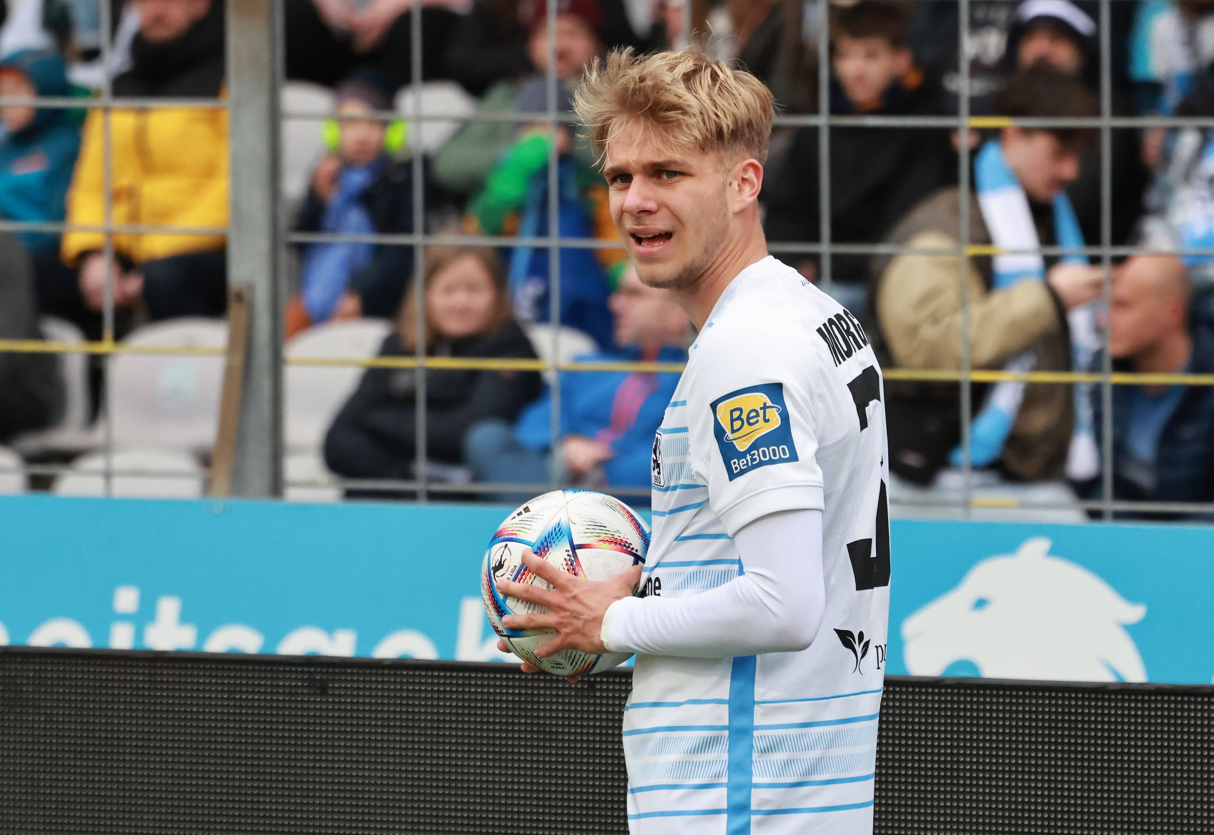 Leandro Morgalla hält beim Drittligaspiel von 1860 München gegen den VfL Osnabrück am 8. April 2023 den Ball zum Einwurf in der Hand.
