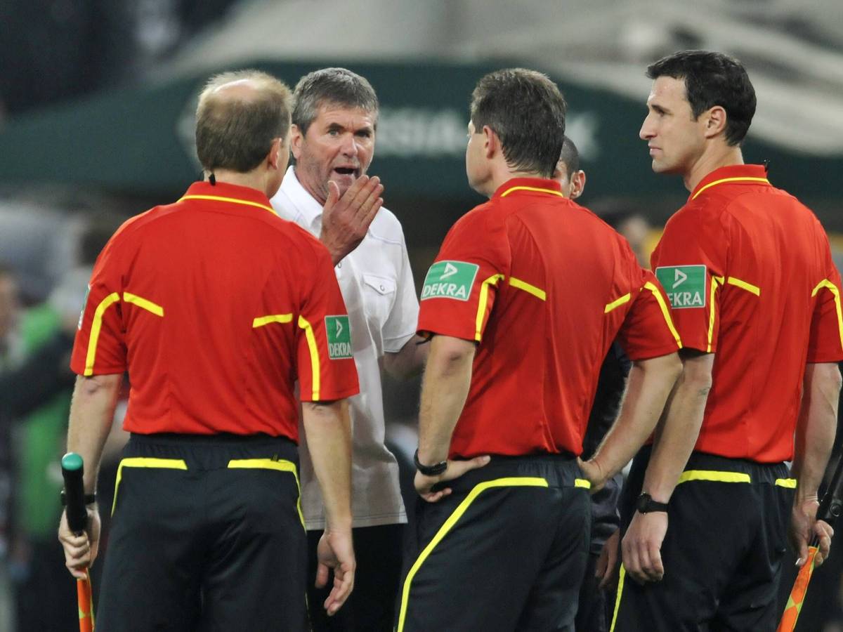 Ex-Bochum-Trainer Friedhelm Funkel diskutiert mit dem Schiedsrichtergespann während des Bundesliga-Relegationskrimis am 19. Mai 2011 gegen Borussia Mönchengladbach im Borussia-Park. Funkel gestikuliert und schimpft sichtlich aufgebracht.