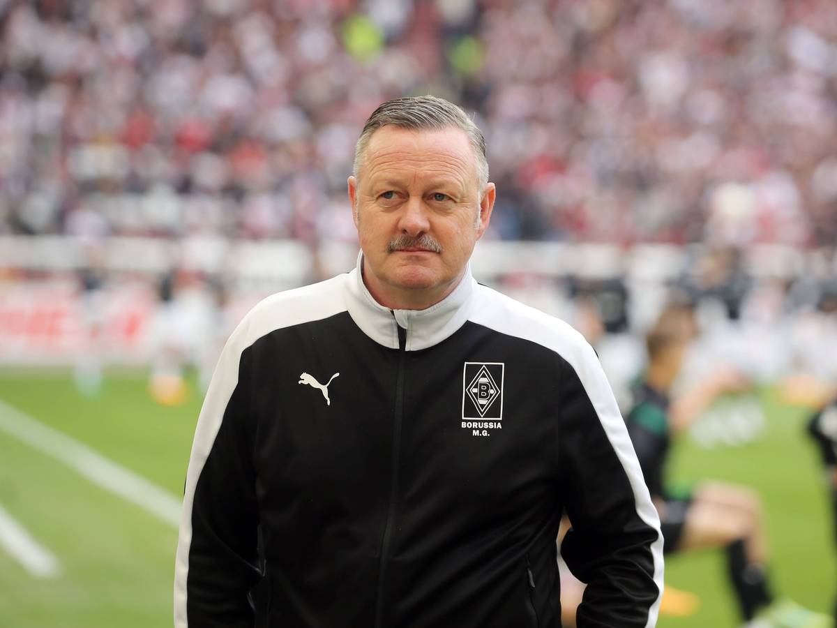 Roland Virkus ist Manager bei Fußball-Bundesligist Borussia Mönchengladbach. Hier ist der 56-Jährige am 29. April 2023 vor der Bundesligapartie beim VfB Stuttgart zu sehen. Virkus blickt in das Stadionrund, im Hintergrund wärmen sich Spieler auf.