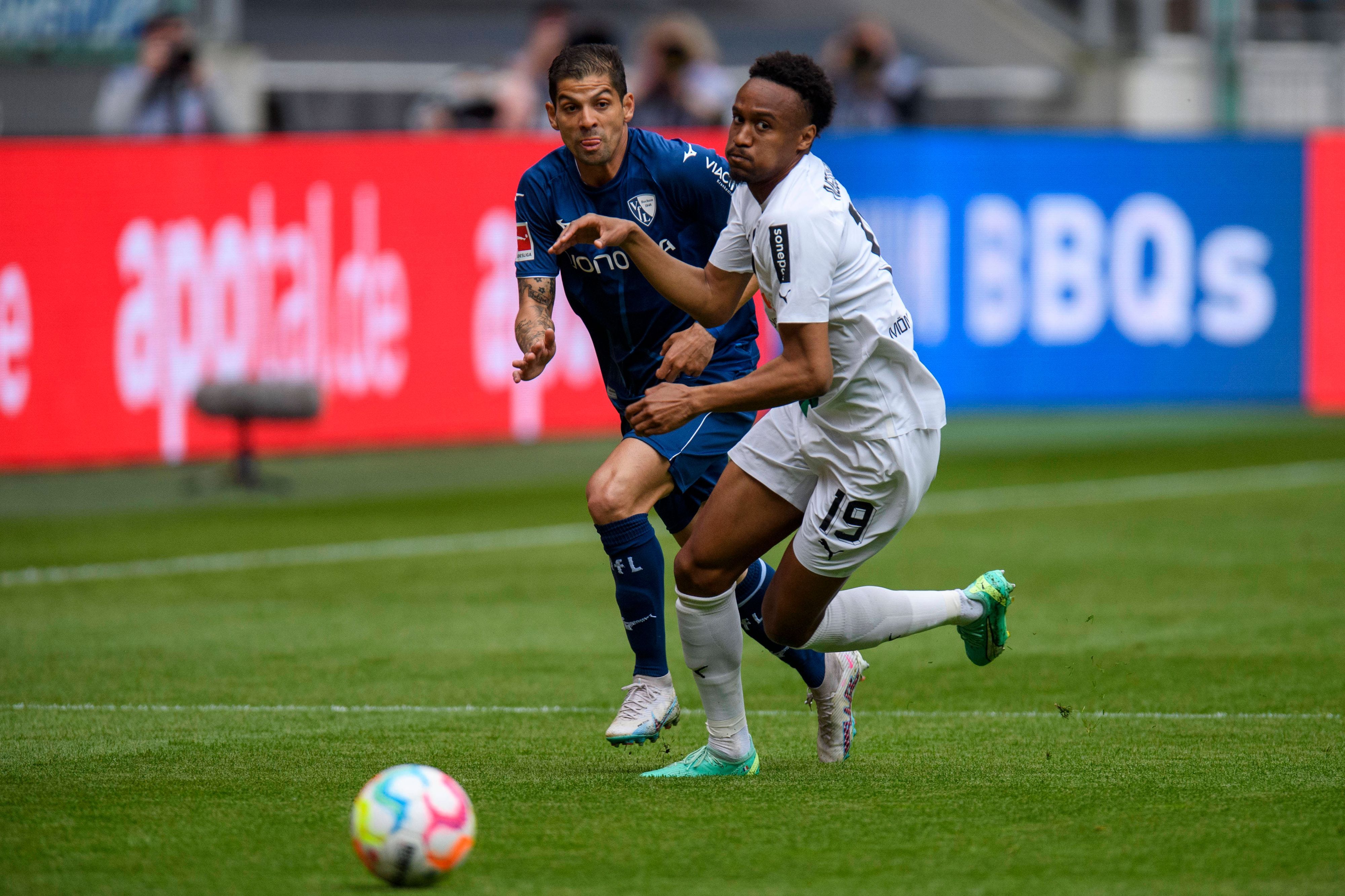 Den Ball im Blick. Nathan Ngoumou (r.) von Borussia Mönchengladbach und Cristian Gamboa vom VfL Bochum am 6. Mai 2023 im Laufduell um das Spielgerät.