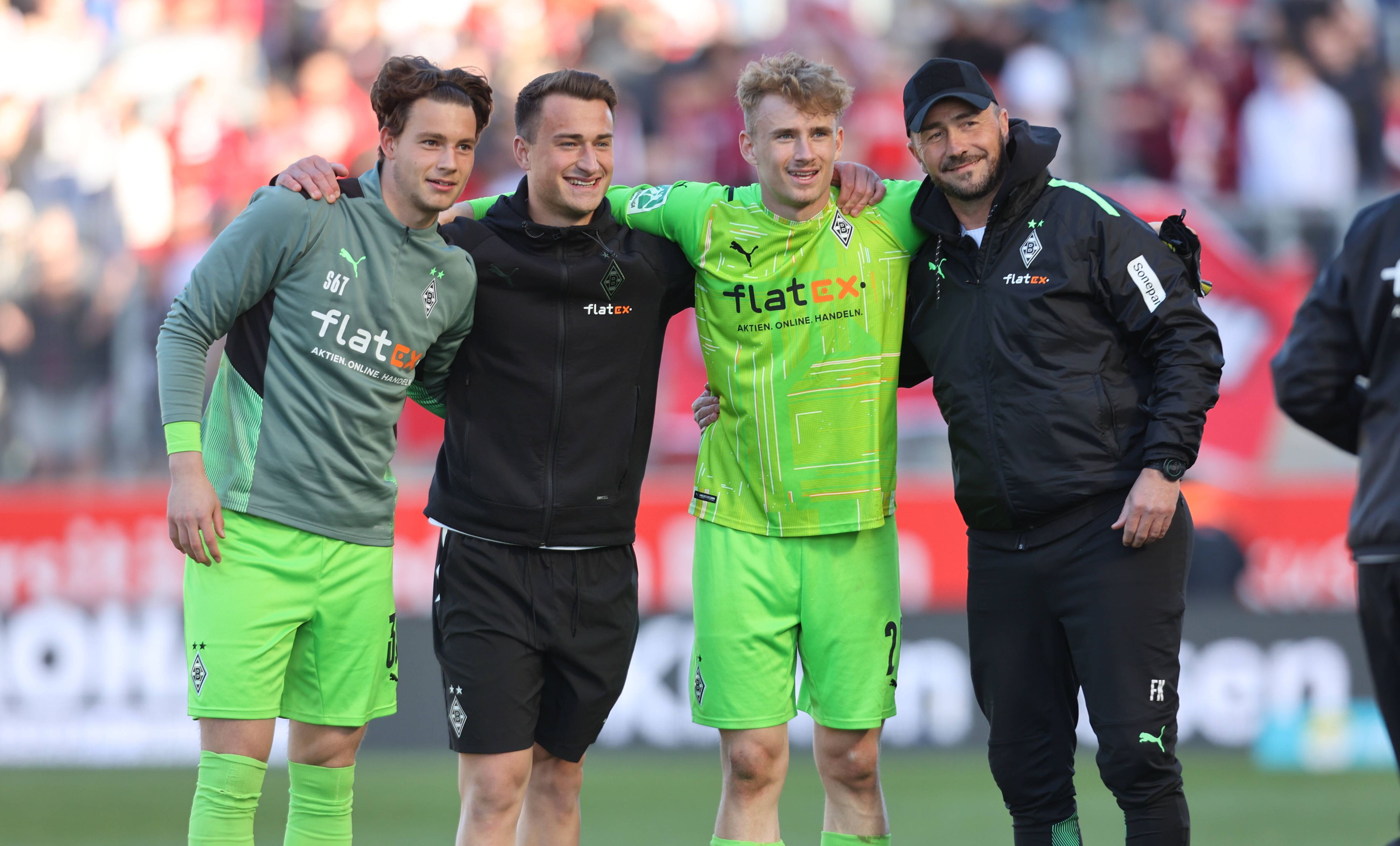 Die Keeper Ben Zich, Maximilian Brüll und Jonas Kersken (v.l.n.r.) gemeinsam mit Ex-Gladbach-Torwart-Trainer Frank Kackert (r.), hier zu sehen am 16. April 2022 beim Regionalliga-Duell der Borussia gegen Rot-Weiss Essen. Spieler und Trainer umarmen sich.