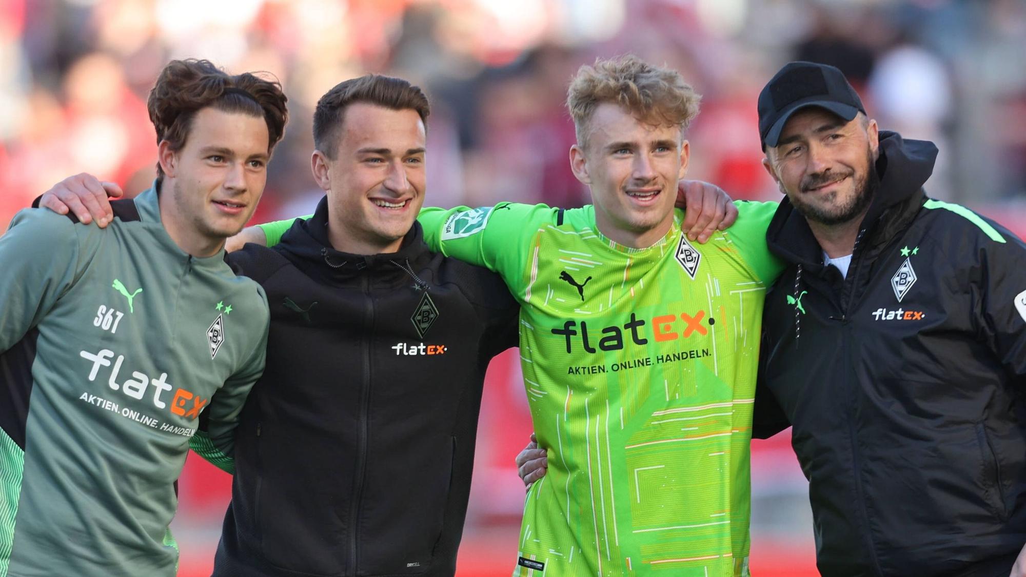 Die Keeper Ben Zich, Maximilian Brüll und Jonas Kersken (v.l.n.r.) gemeinsam mit Ex-Gladbach-Torwart-Trainer Frank Kackert (r.), hier zu sehen am 16. April 2022 beim Regionalliga-Duell der Borussia gegen Rot-Weiss Essen. Spieler und Trainer umarmen sich.