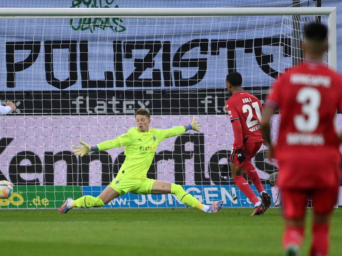 Amine Adli (Nummer 21) erzielt im Bundesliga-Spiel von Bayer Leverkusen bei Borussia Mönchengladbach am 22. Januar 2023 den Treffer zum zwischenzeitlichen 2:0. Jonas Omlin versucht vergeblich, den Ball zu parieren.