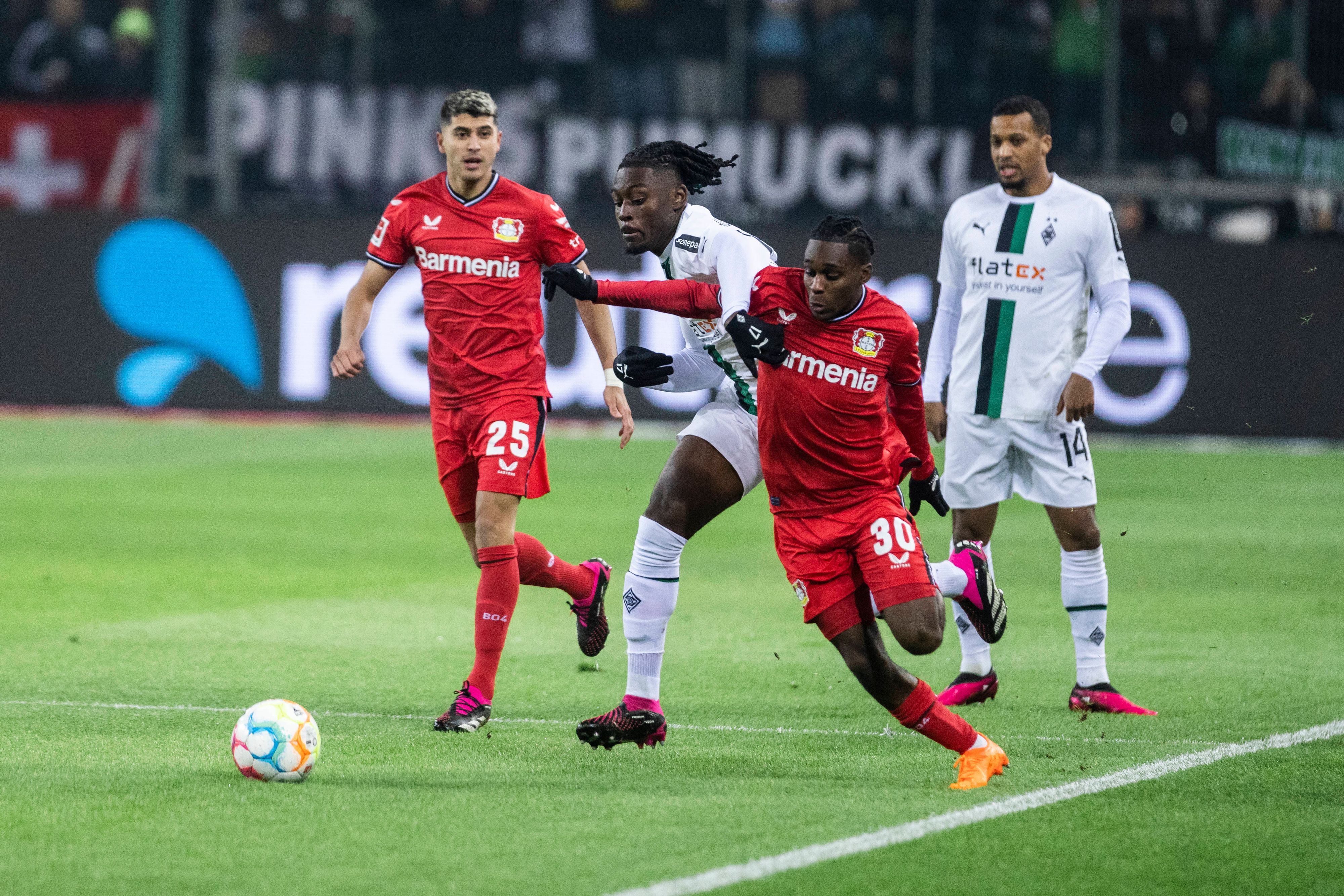 Gladbach-Profi Manu Koné (M.) hat gegen Jeremie Frimpong (r.) von Bayer Leverkusen große Mühe im Zweikampf. Das Foto stammt aus dem Hinspiel am 22. Januar 2023 im Borussia-Park. Koné verliert das Laufduell.