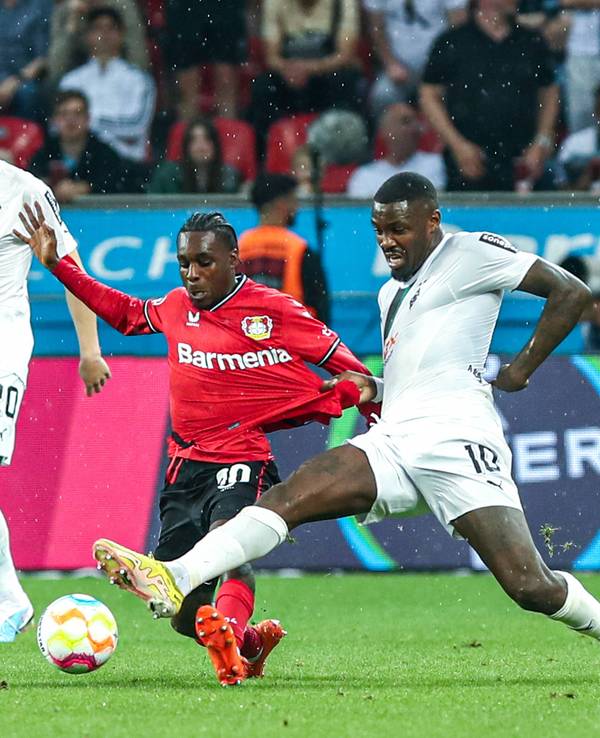 Borussia Mönchengladbach hat am Sonntag (21. Mai 2023) 2:2 bei Bayer 04 Leverkusen gespielt. Das Foto zeigt Leverkusens Jeremy Frimpong (l.) im Zweikampf mit Gladbachs Marcus Thuram (r.).