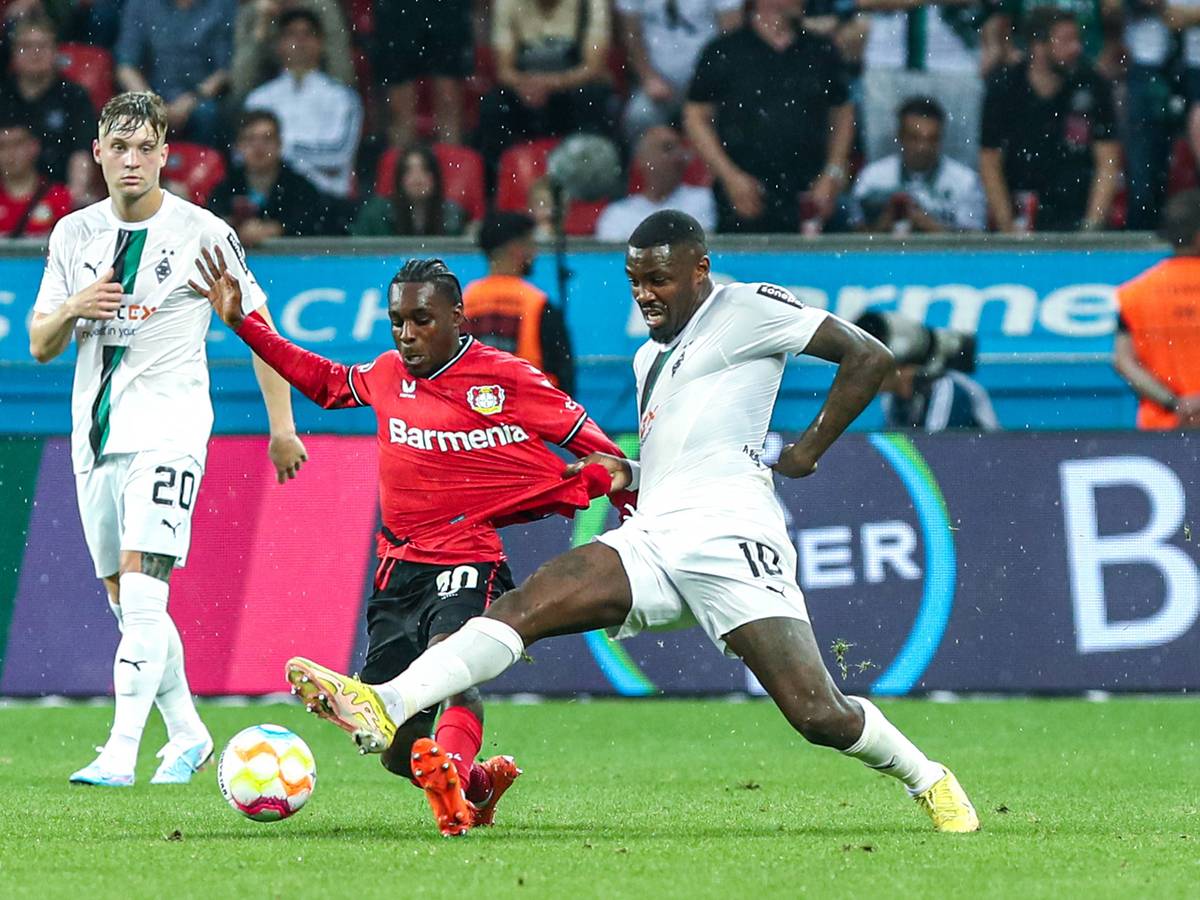 Borussia Mönchengladbach hat am Sonntag (21. Mai 2023) 2:2 bei Bayer 04 Leverkusen gespielt. Das Foto zeigt Leverkusens Jeremy Frimpong (l.) im Zweikampf mit Gladbachs Marcus Thuram (r.).