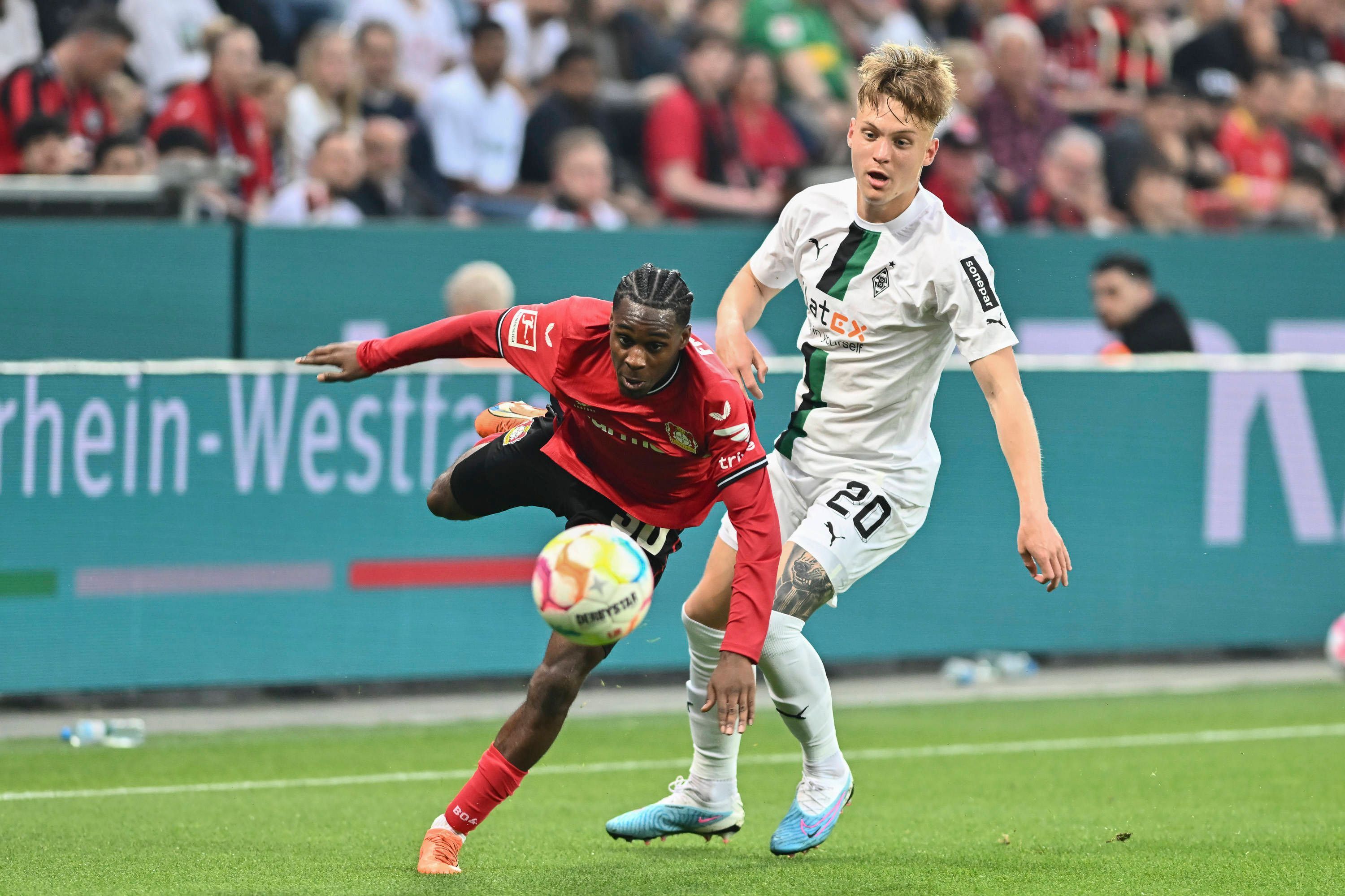Luca Netz von Borussia Mönchengladbach (r.) am 21. Mai 2023 im Zweikampf mit Jeremy Frimpong von Bayer Leverkusen.