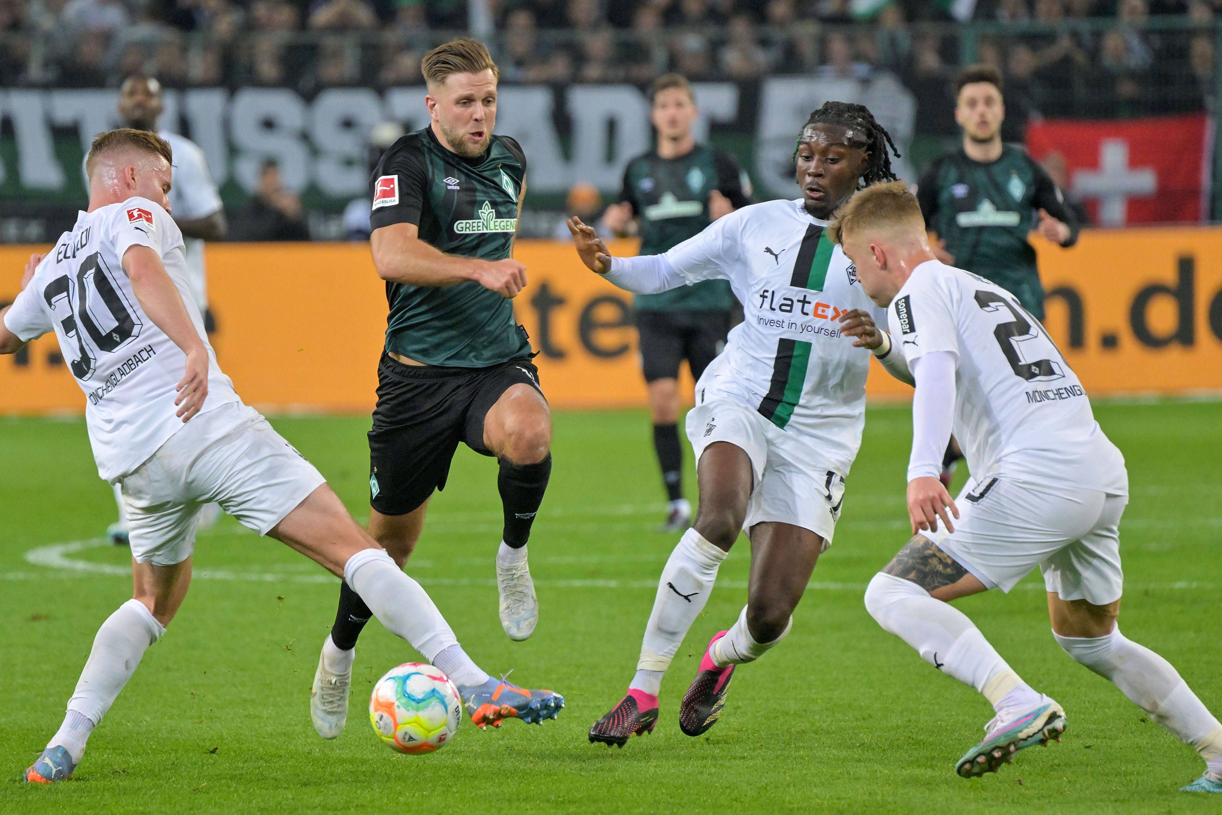 Die Gladbach-Profis Nico Elvedi (l.), Luca Netz (r.) und Manu Koné (2.v.r.) im Duell mit Werder-Bremen-Stürmer Niclas Füllkurg. Das Foto ist am 17. März 2023 im Borussia-Park entstanden. Füllkrug setzt energisch dem Ball nach.