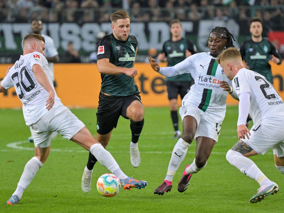 Die Gladbach-Profis Nico Elvedi (l.), Luca Netz (r.) und Manu Koné (2.v.r.) im Duell mit Werder-Bremen-Stürmer Niclas Füllkurg. Das Foto ist am 17. März 2023 im Borussia-Park entstanden. Füllkrug setzt energisch dem Ball nach.