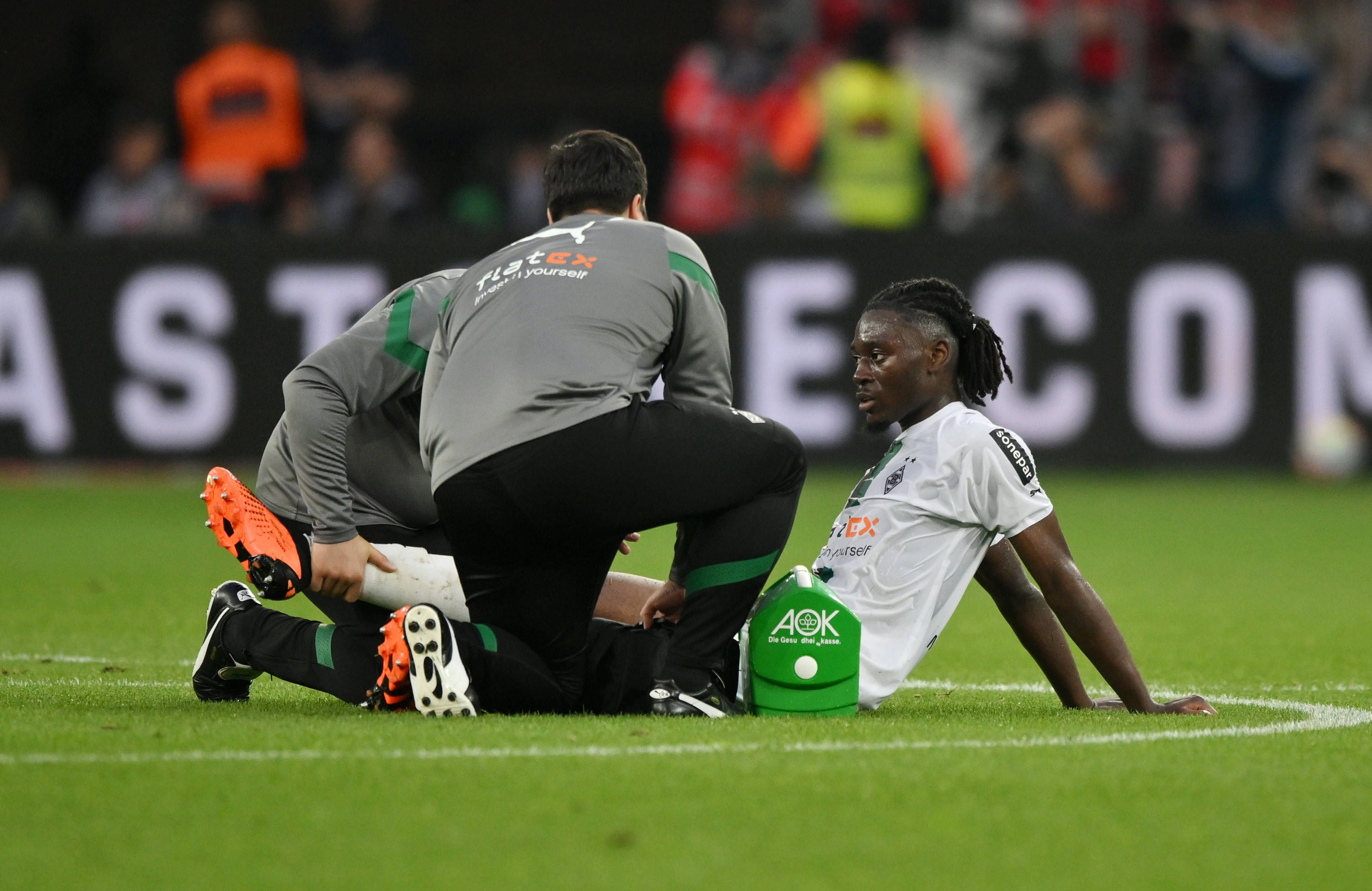 Manu Koné, Mittelfeldspieler von Borussia Mönchengladbach, am Sonntag (21. Mai 2023) beim Auswärtsspiel in Leverkusen bei der Behandlung durch die Betreuer auf dem Platz.