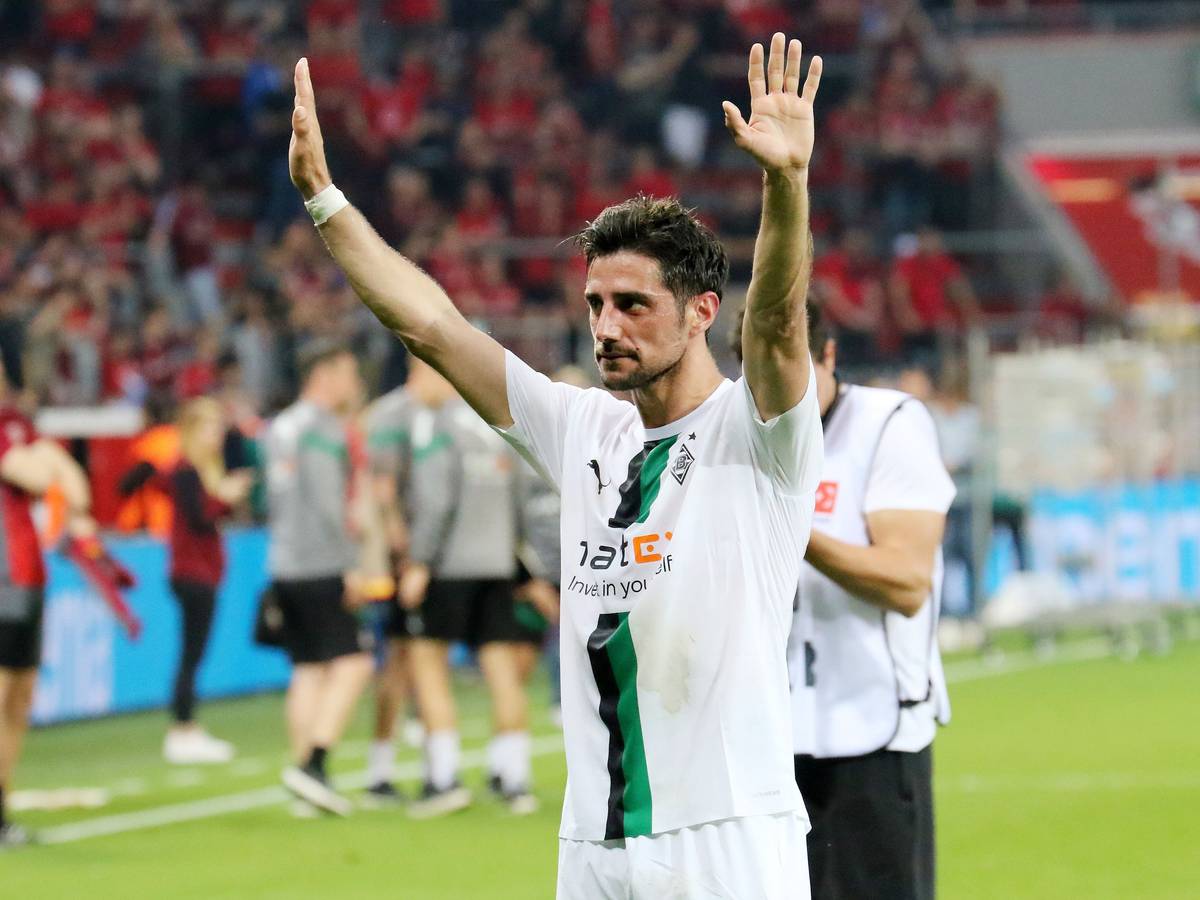 Lars Stindl, Kapitän von Borussia Mönchengladbach, bedankt sich nach dem Bundesliga-Auswärtsspiel gegen Bayer Leverkusen (21. Mai 2023) bei den mitgereisten Fans. Stindl hat beide Arme erhoben.