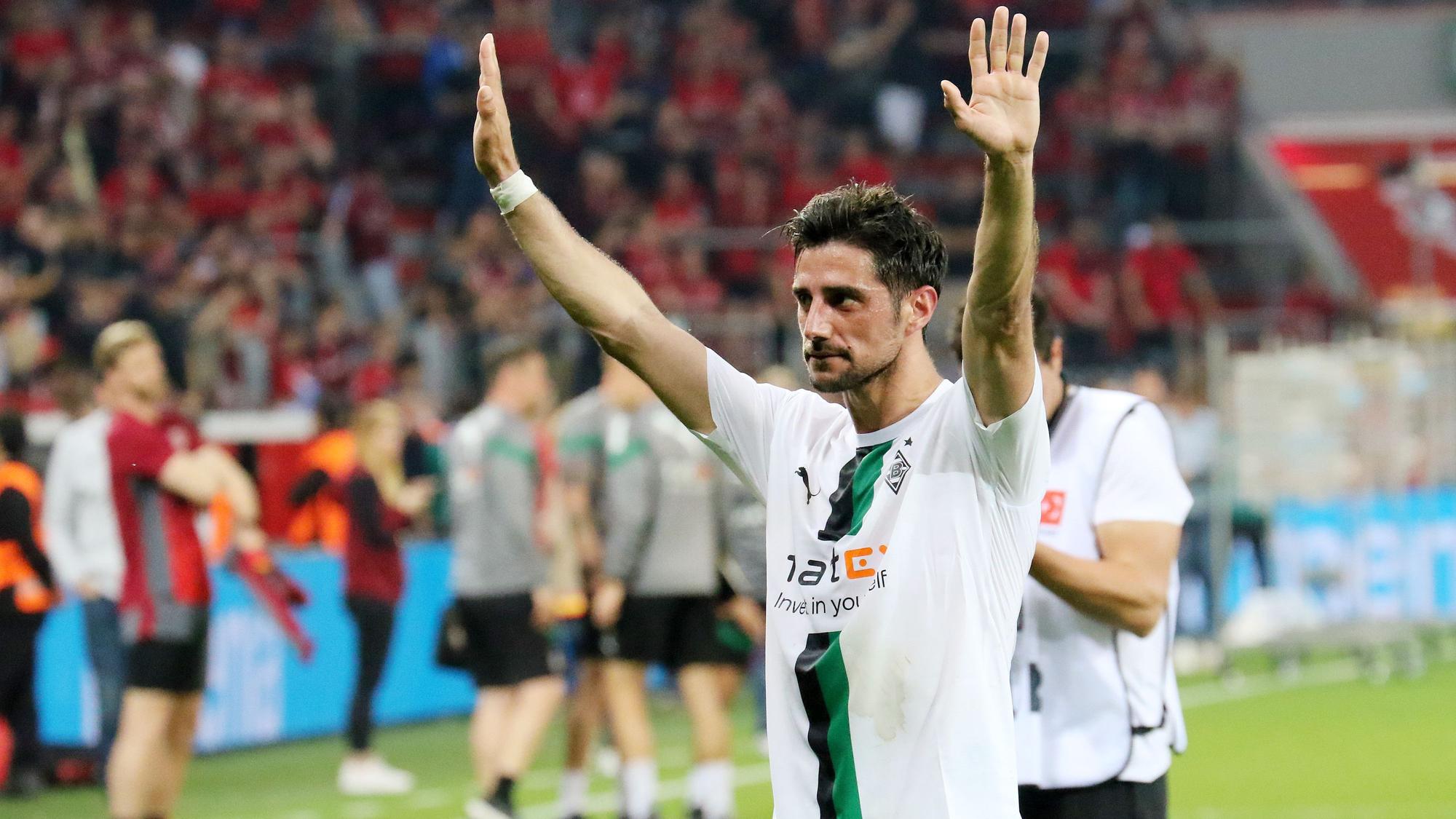 Lars Stindl, Kapitän von Borussia Mönchengladbach, bedankt sich nach dem Bundesliga-Auswärtsspiel gegen Bayer Leverkusen (21. Mai 2023) bei den mitgereisten Fans. Stindl hat beide Arme erhoben.