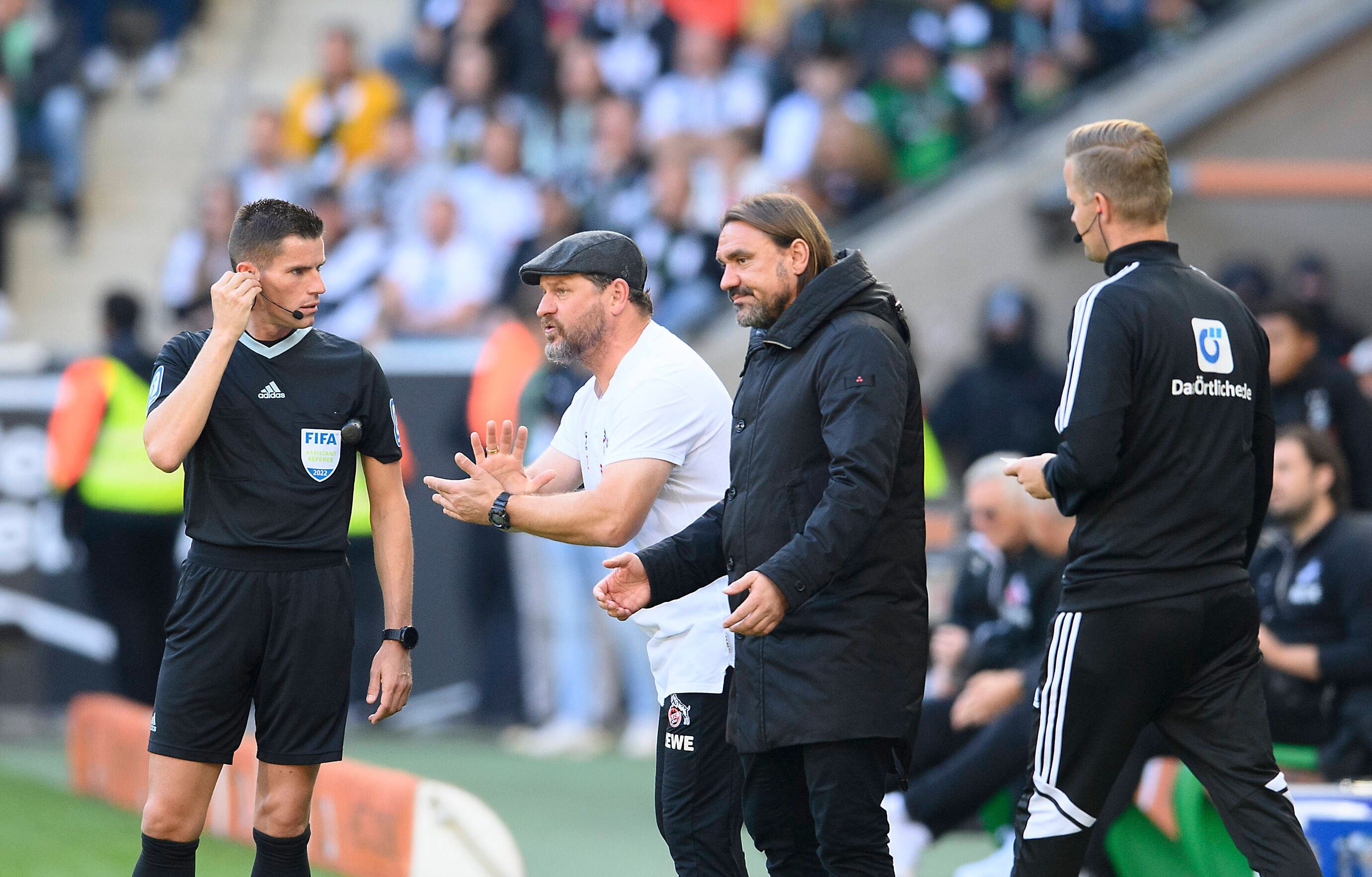 Wer steht am Saisonende vor dem Erzrivalen in der Bundesliga-Abschlusstabelle? Gladbach-Trainer Daniel Farke (2.v.r.) oder Köln-Coach Steffen Baumgart (2.v.l.)? Hier sind die beiden am 9. Oktober 2022 im Borussia-Park zu sehen. Beide Trainer machen Gesten mit ihren Händen.