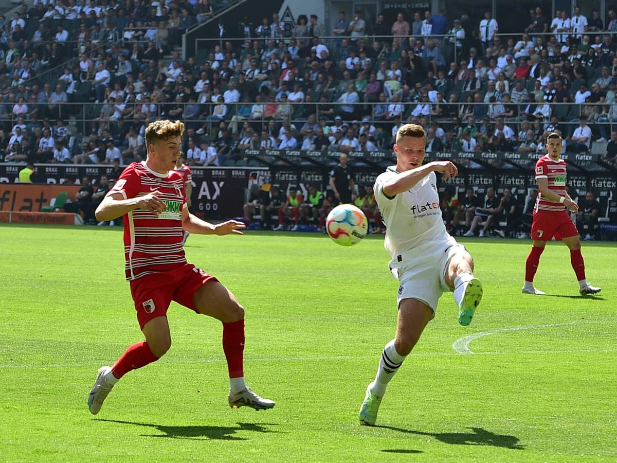 Borussia Mönchengladbach hat am Samstag (27. Mai 2023) 2:0 gegen den FC Augsburg gewonnen. Das Foto zeigt FCA-Profi Arne Engels (l.) im Kampf um den Ball mit BMG-Verteidiger Nico Elvedi (r.).