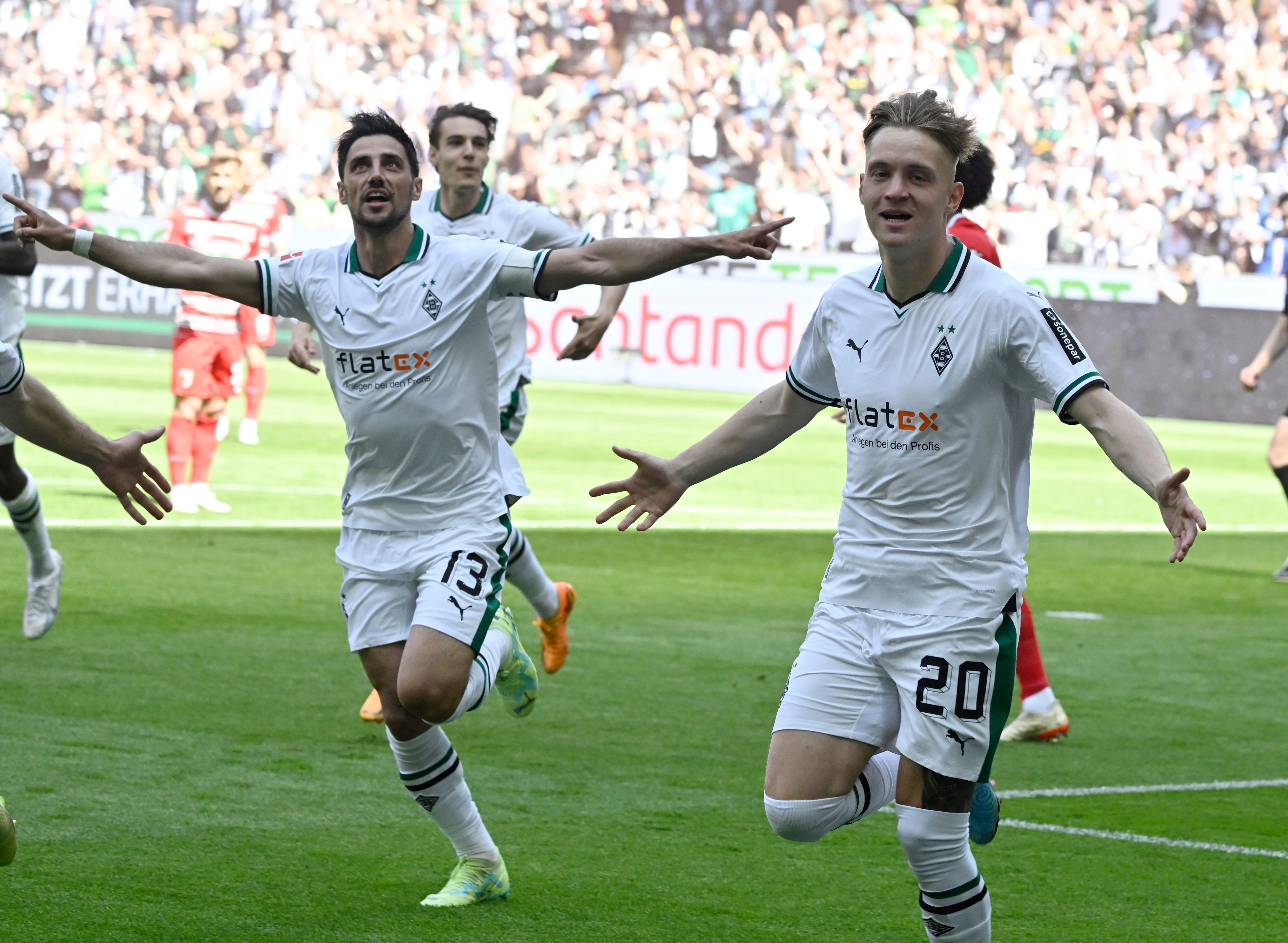Luca Netz (r.) und Lars Stindl jubeln über einen Treffer von Borussia Mönchengladbach im Bundesliga-Finish (27. Mai 2023) gegen den FC Augsburg im Borussia-Park. Sie breiten die Arme zum Jubel aus.
