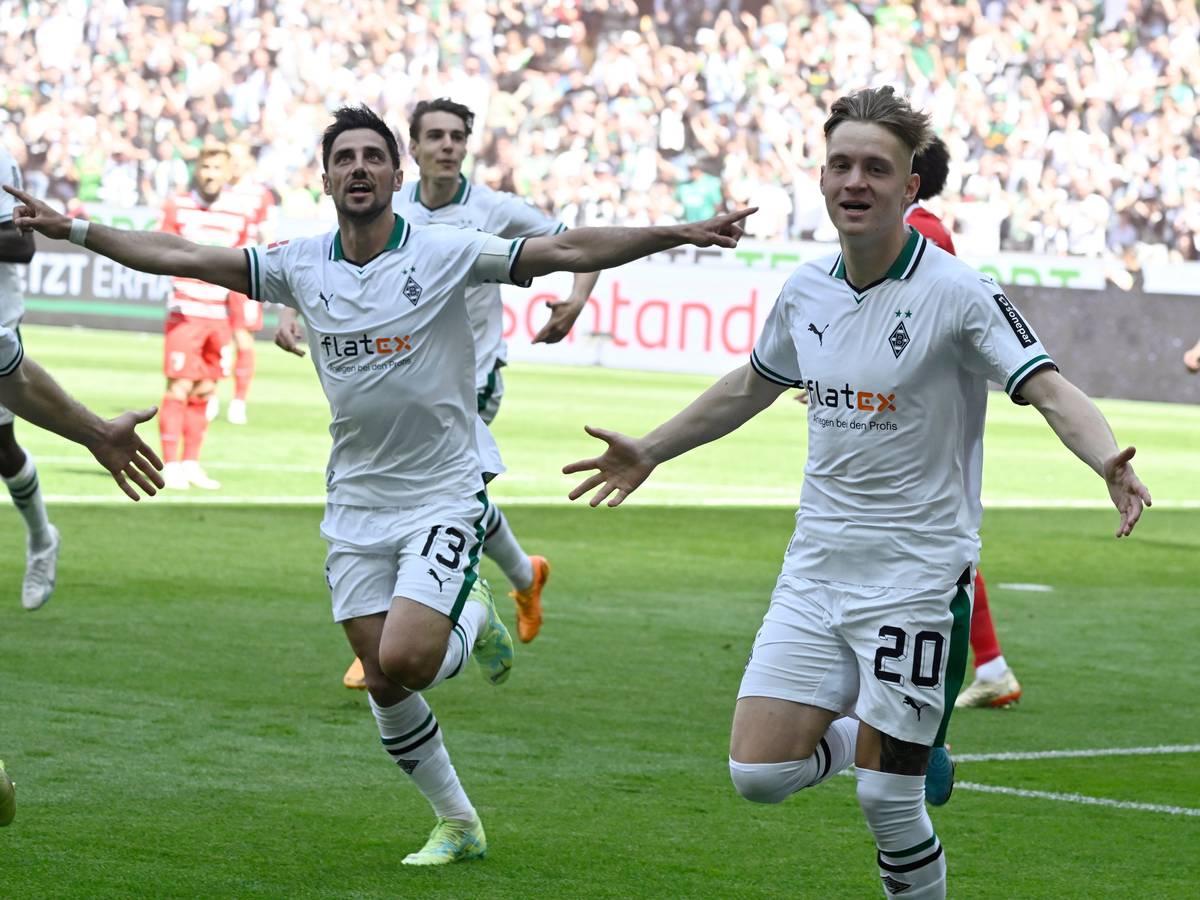 Luca Netz (r.) und Lars Stindl jubeln über einen Treffer von Borussia Mönchengladbach im Bundesliga-Finish (27. Mai 2023) gegen den FC Augsburg im Borussia-Park. Sie breiten die Arme zum Jubel aus.