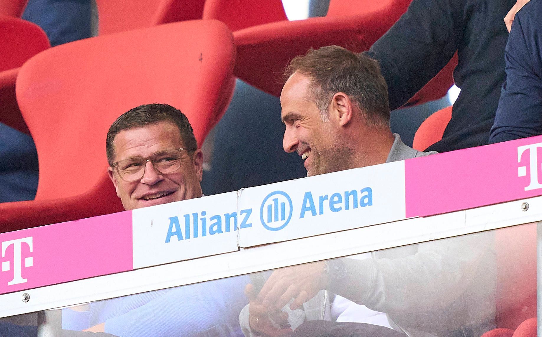 RB-Sportgeschäftsführer Max Eberl (l.) und Oliver Mintzlaff (r.), Geschäftsführer RB Leipzig, hier zu sehen am 20. Mai 2023 während der Bundesligapartie bei Bayern München in der Allianz-Arena. Beide lächeln.