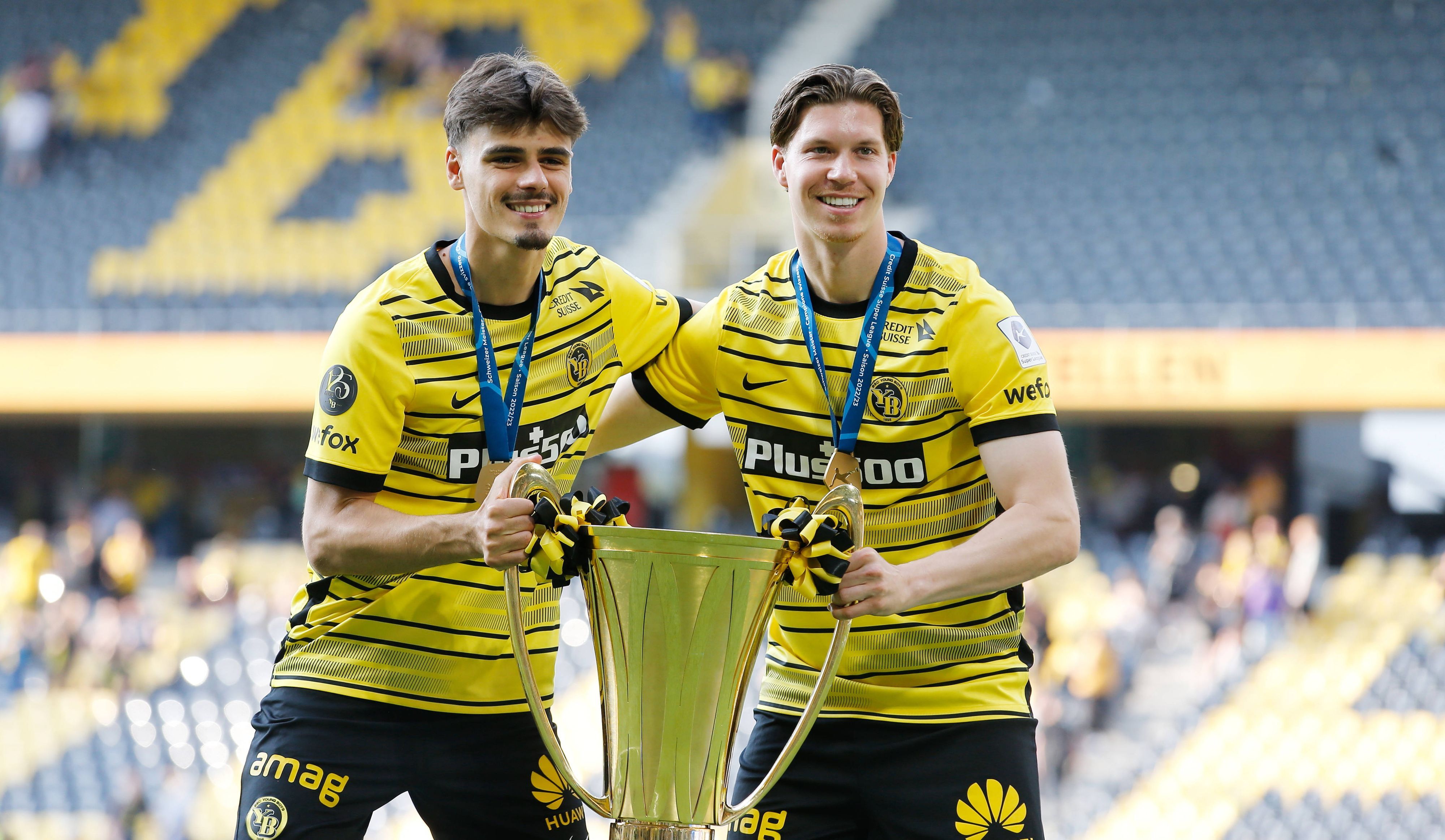 Donat Rrudhani (l.) und Cedric Itten am 29. Mai 2023 feiern die Meisterschaft der Schweizer Super League mit Young Boys Bern. In den Händen halten sie den goldenen Pokal.