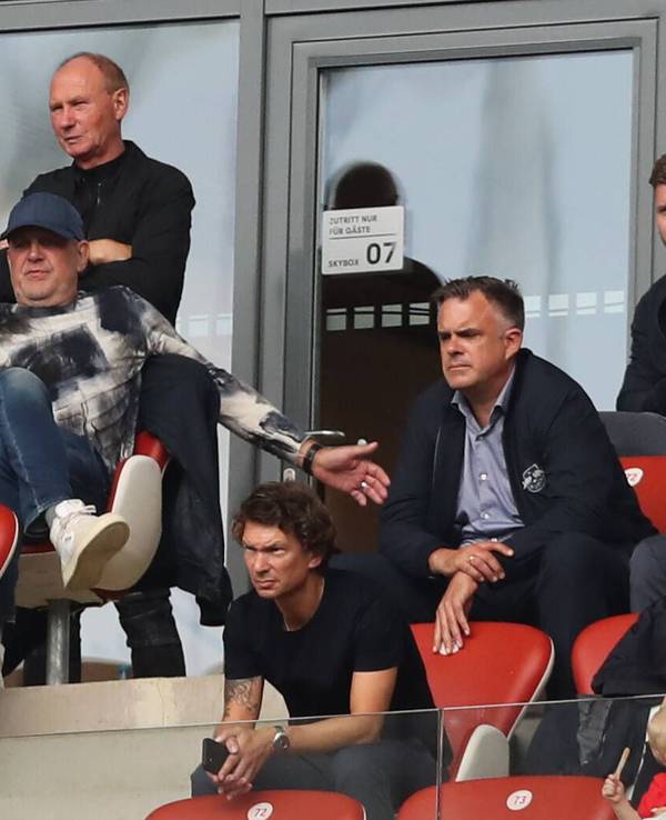 Nils Schmadtke (ober Reihe, links) sitzt neben seinem Vater Jörg Schmadtke, der inzwischen für den FC Liverpool arbeitet. Die beiden sind hier am 27. August 2022 in Leipzig zu sehen. Jörg Schmadtke macht Bewegungen mit den Armen.