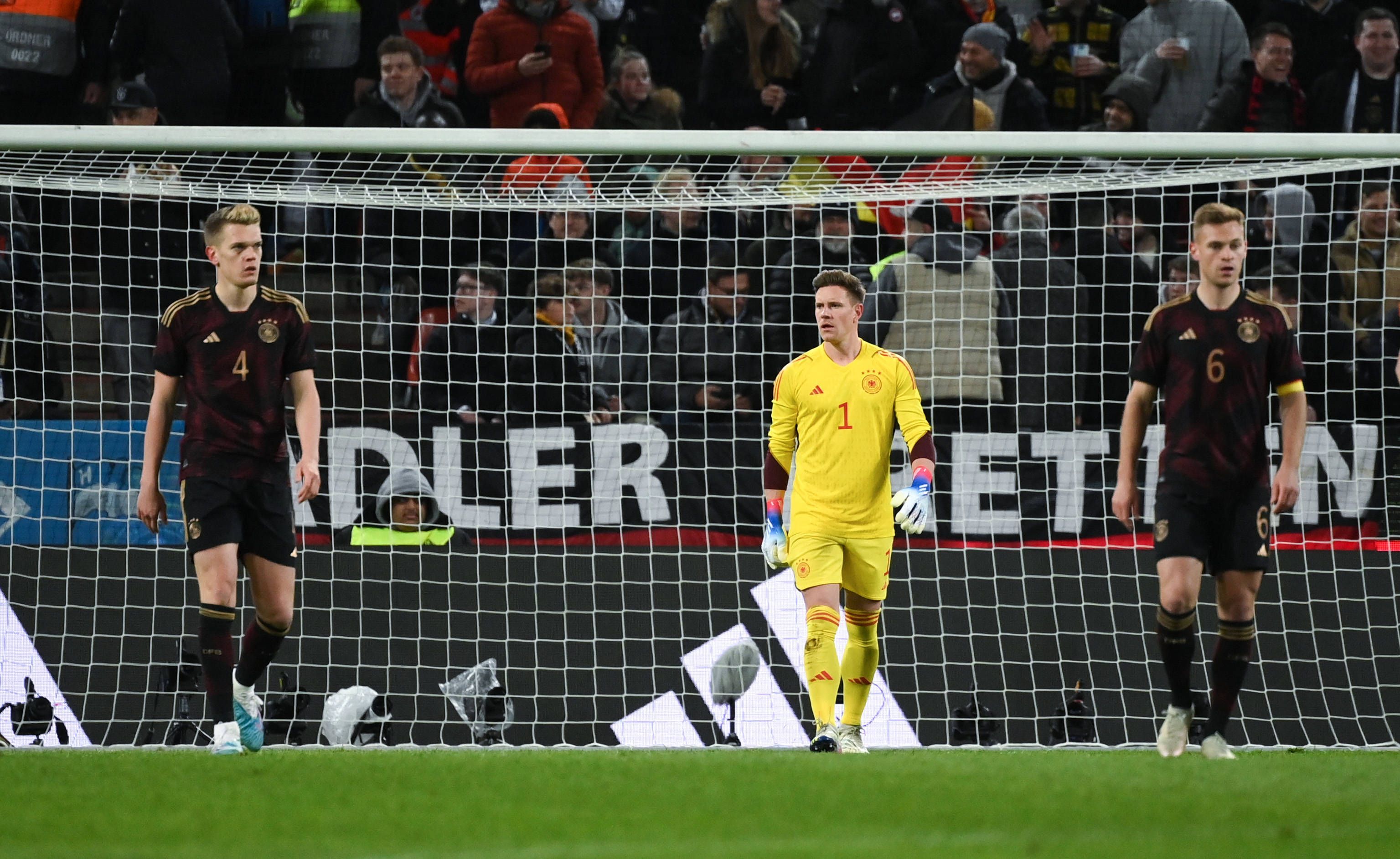 DFB-Nationalspieler Marc-André ter Stegen (M.), hier zu sehen mit Joshua Kimmich (r.) und Matthias Ginter (l.) am 28. März 2023 während des Länderspiels gegen Belgien in Köln. Ter Stegen schaut zu seinen Vorderleuten.