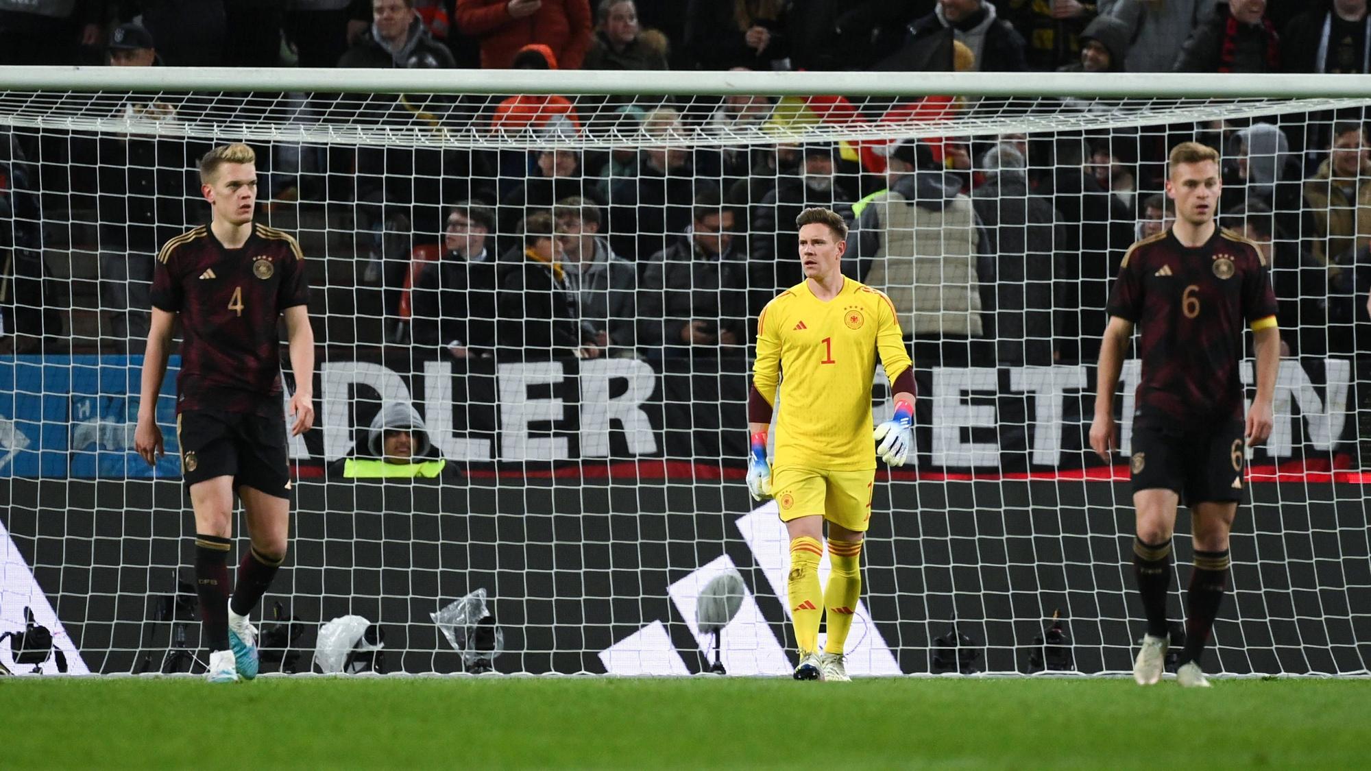 DFB-Nationalspieler Marc-André ter Stegen (M.), hier zu sehen mit Joshua Kimmich (r.) und Matthias Ginter (l.) am 28. März 2023 während des Länderspiels gegen Belgien in Köln. Ter Stegen schaut zu seinen Vorderleuten.