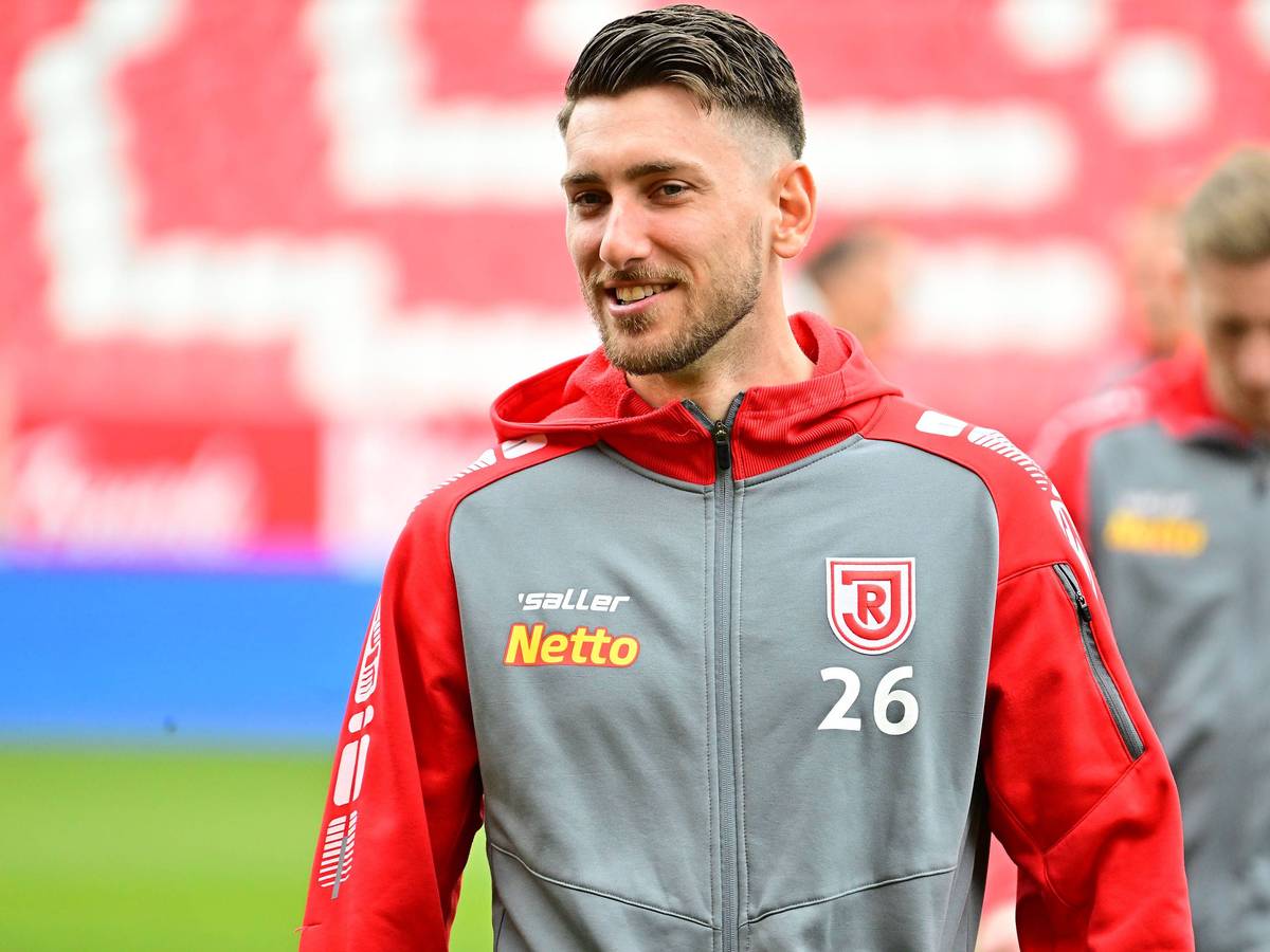 Charalambos Makridis, Ex-Spieler aus der U23 von Borussia Mönchengladbach, am 23.04.2023 vor einem Zweitligaspiel des SSV Jahn Regensburg gegen den 1. FC Kaiserslautern lächelnd.