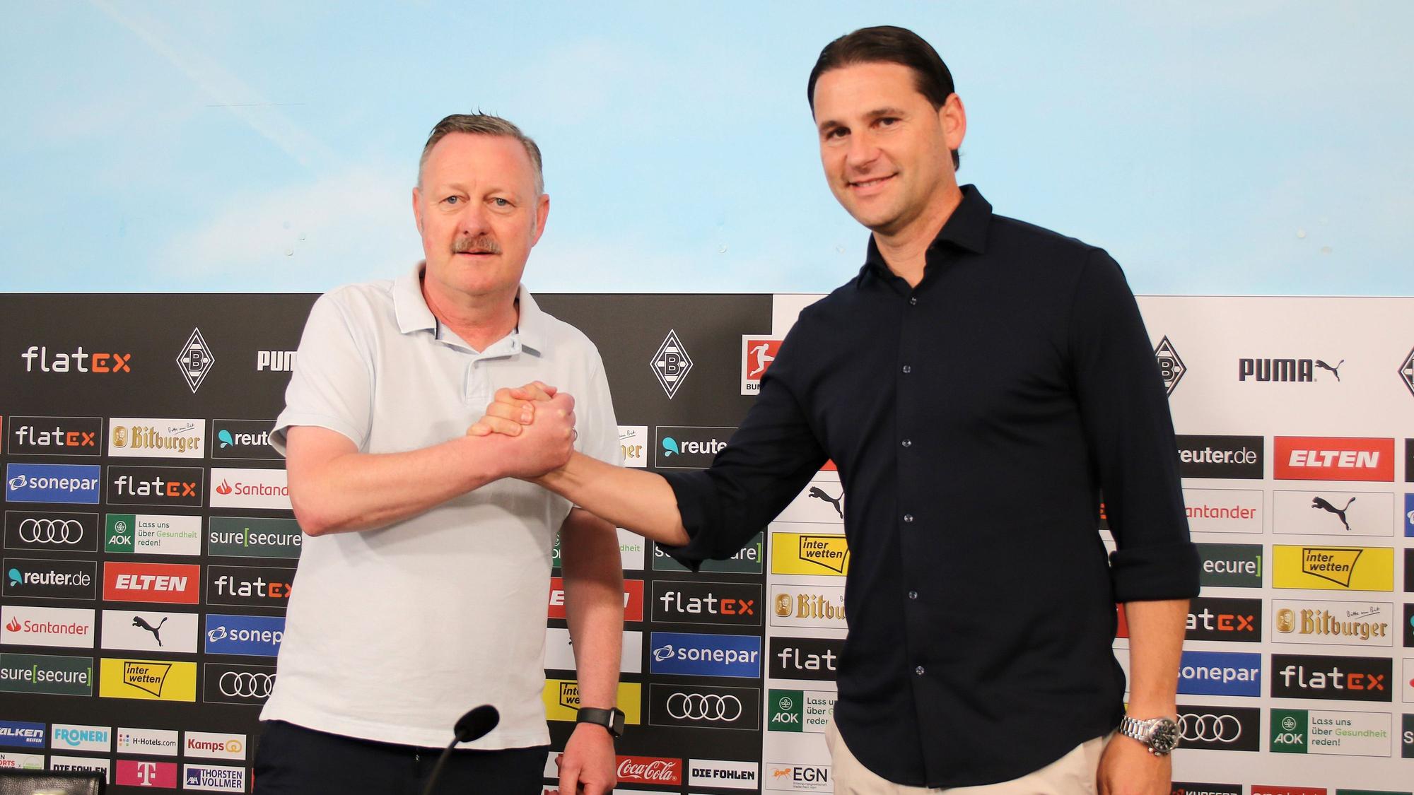Der neue Gladbach-Trainer Gerardo Seoane (r.) und Borussia-Manager Roland Virkus (l.), hier zu sehen bei einer Pressekonferenz im Borussia-Park am 9. Juni 2023. Beide klatschen sich ab und lächeln Richtung Fotografen.