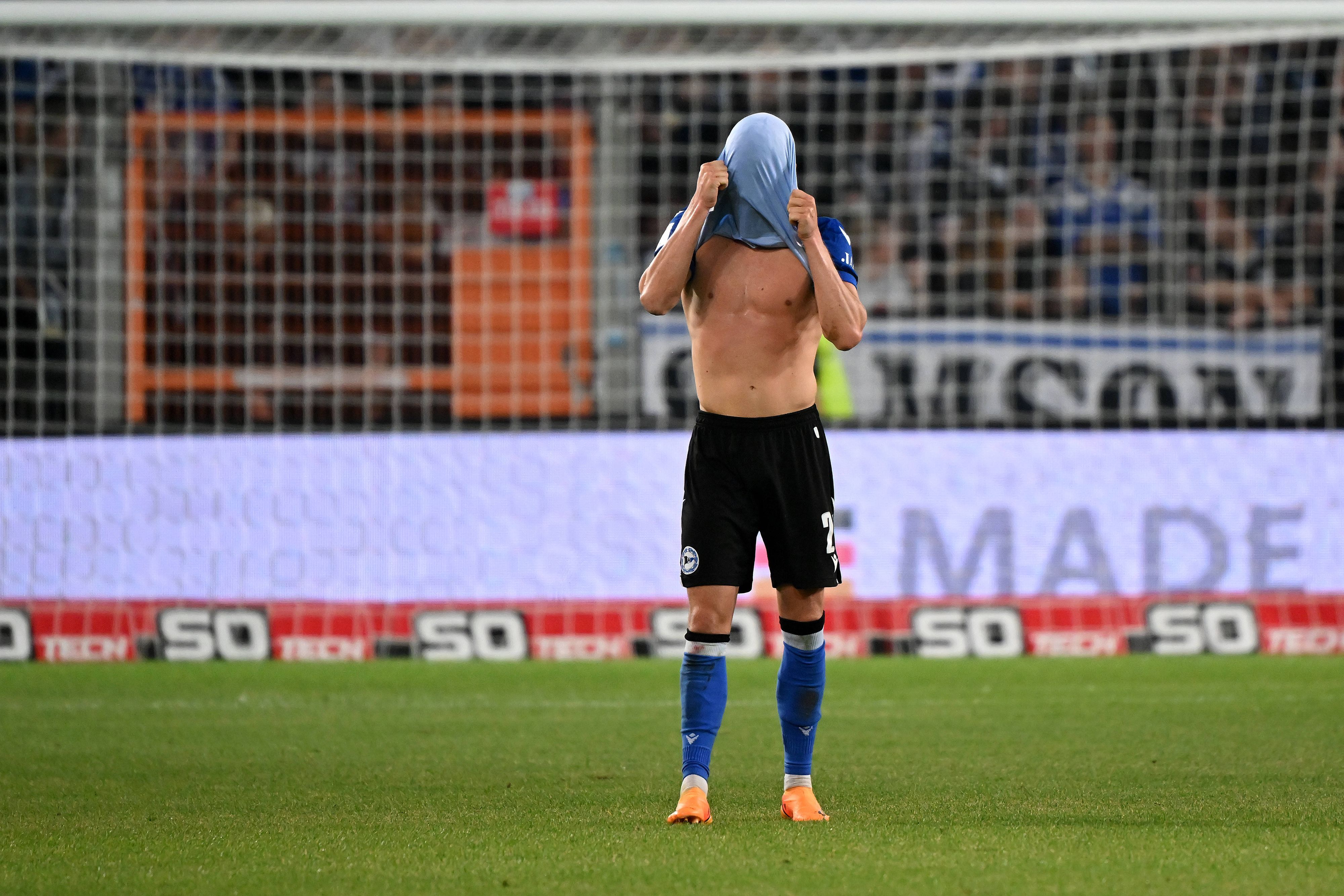 Aus Frust zieht sich Robin Hack nach dem Relegationsspiel von Arminia Bielefeld gegen den SV Wehen-Wiesbaden am 6. Juni 2023 das Trikot über den Kopf.