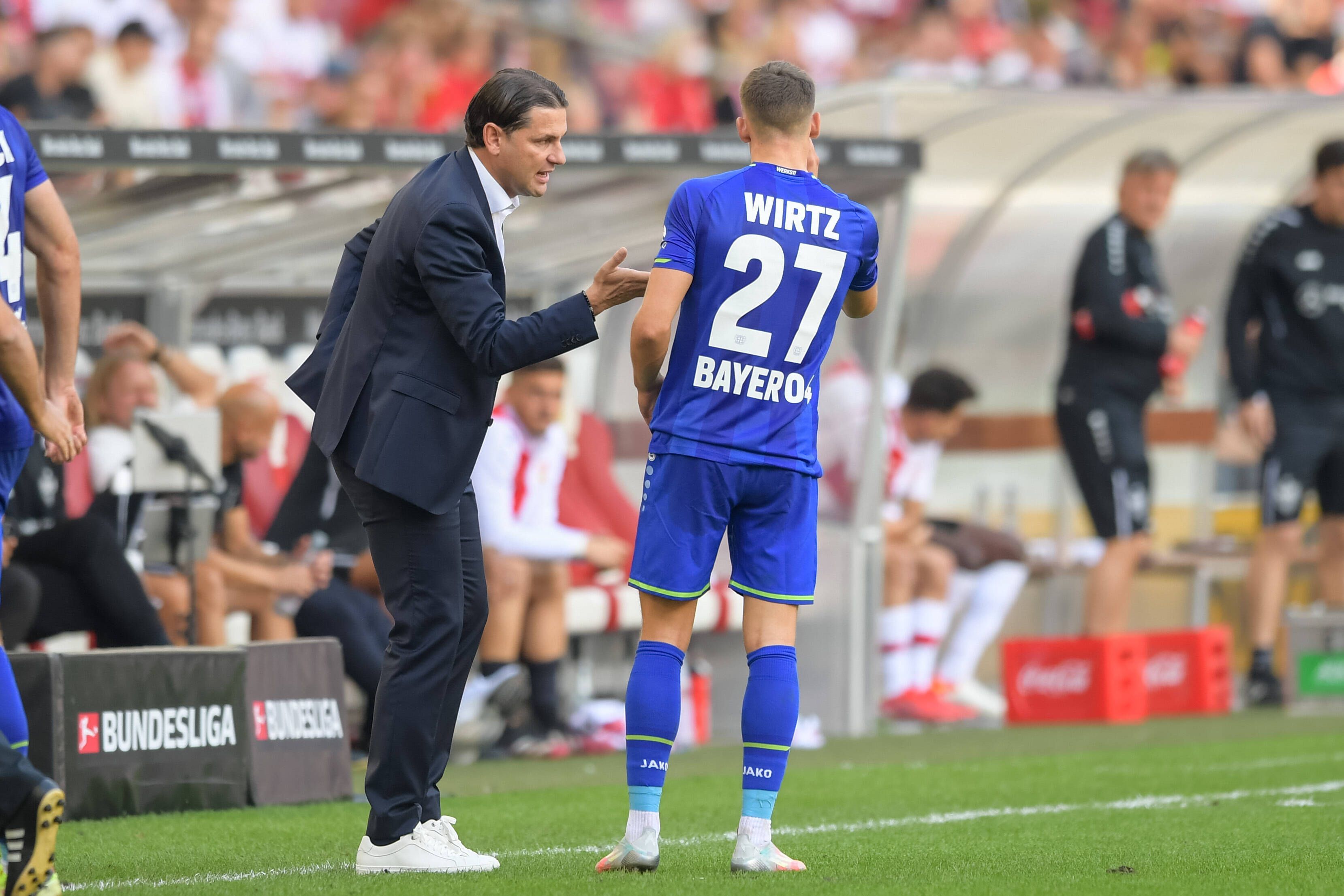 Gerardo Seoane (l.) spricht am 19. September 2021 beim Bundesliga-Auswärtsspiel in Stuttgart in seiner Zeit von Bayer Leverkusen mit Florian Wirtz.