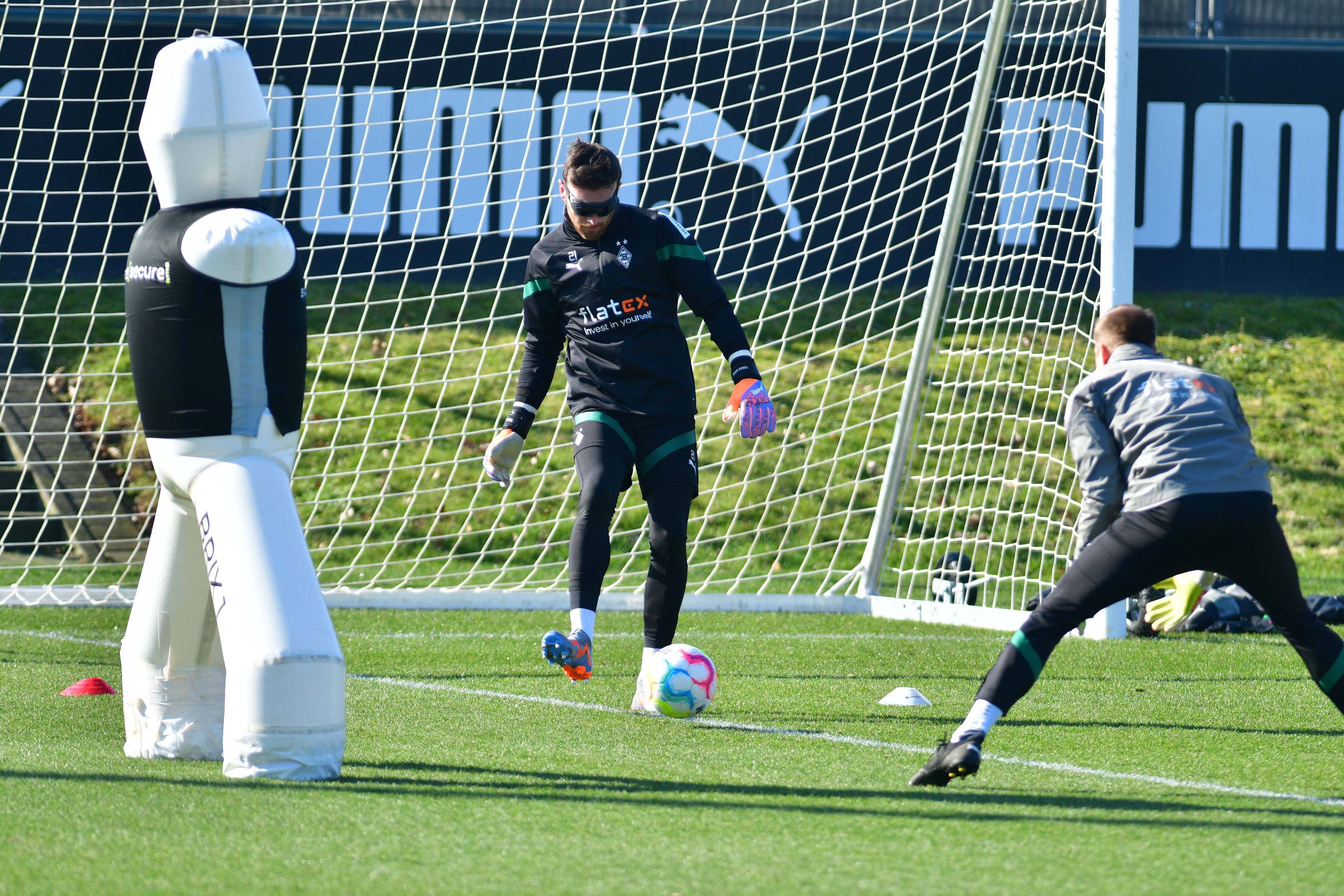 Torwart-Trainer Fabian Otte (r.) führt mit Tobias Sippel eine Übung bei einer Trainings-Einheit von Borussia Mönchengladbach am 1. März 2023 durch. Sippel trägt eine Spezial-Rolle und spielt einen Ball mit dem rechten Fuß.