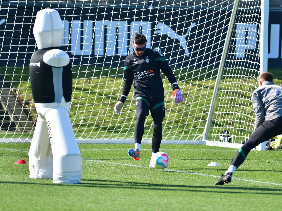 Torwart-Trainer Fabian Otte (r.) führt mit Tobias Sippel eine Übung bei einer Trainings-Einheit von Borussia Mönchengladbach am 1. März 2023 durch. Sippel trägt eine Spezial-Rolle und spielt einen Ball mit dem rechten Fuß.