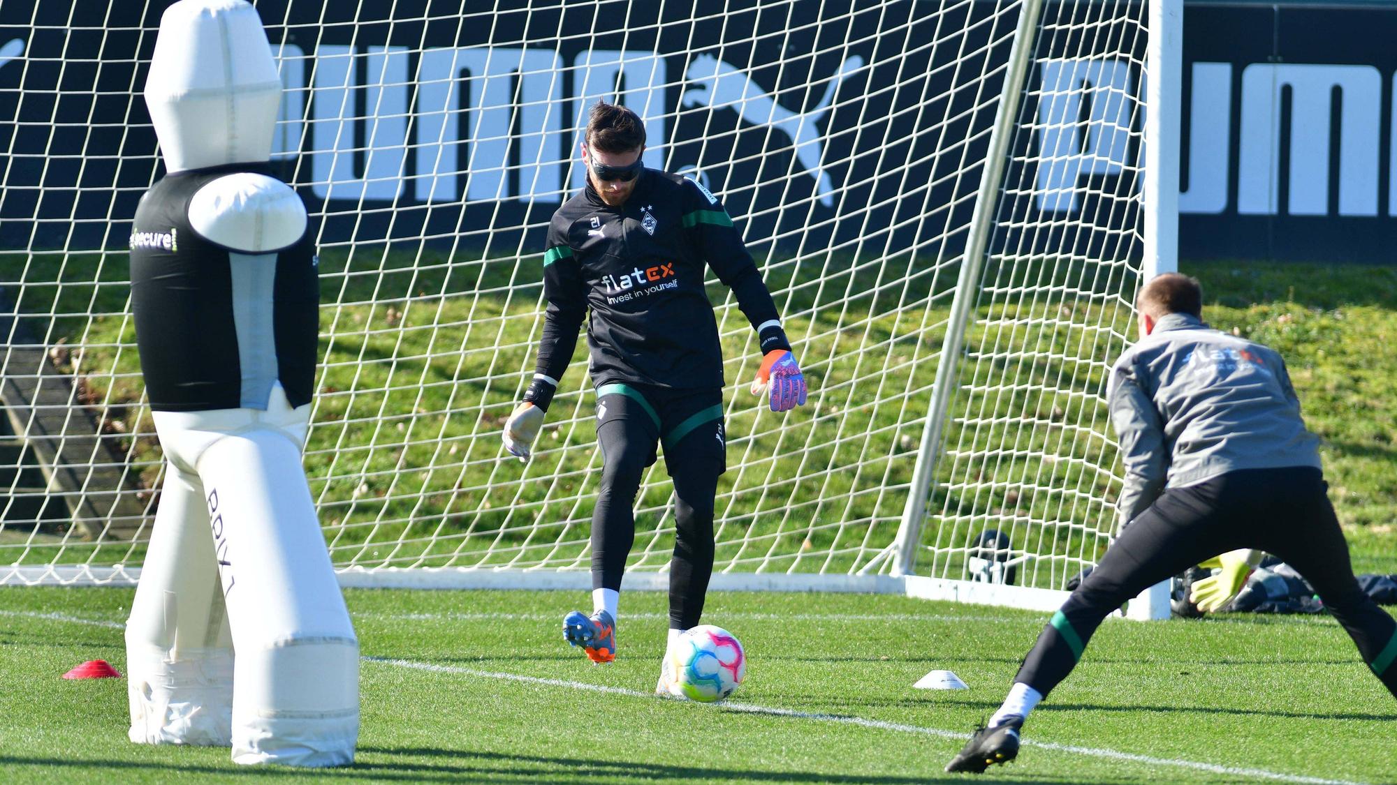 Torwart-Trainer Fabian Otte (r.) führt mit Tobias Sippel eine Übung bei einer Trainings-Einheit von Borussia Mönchengladbach am 1. März 2023 durch. Sippel trägt eine Spezial-Rolle und spielt einen Ball mit dem rechten Fuß.