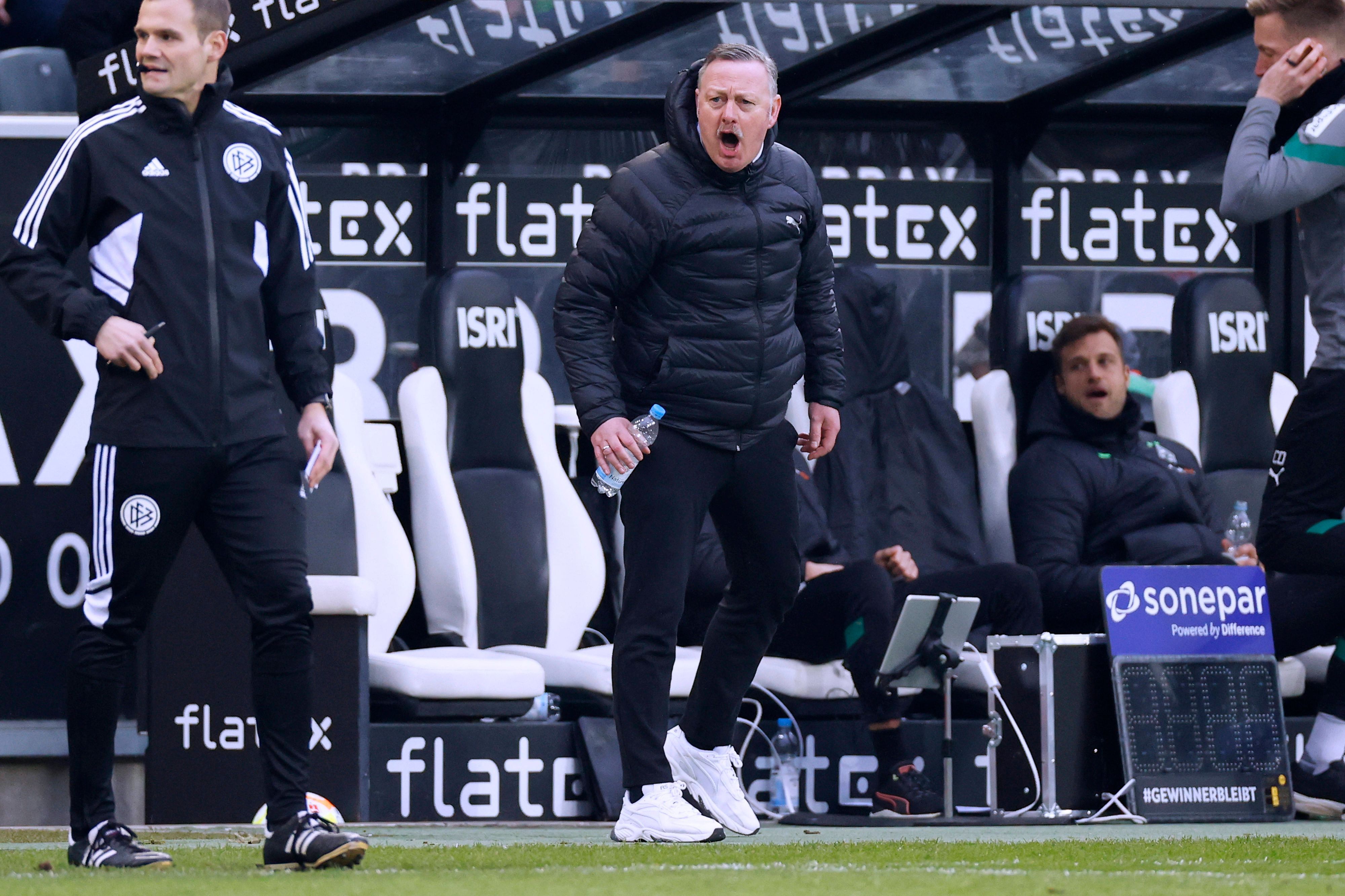 Roland Virkus, Geschäftsführer Sport bei Borussia Mönchengladbach, sitzt künftig während der Fohlen-Spiele nicht mehr auf der Bank am Spielfeldrand. Hier ist er am 4. März 2023 im Borussia-Park zu sehen. Virkus brüllt etwas Richtung Schiedsrichter, er hält eine Falsche Wasser in der Hand.