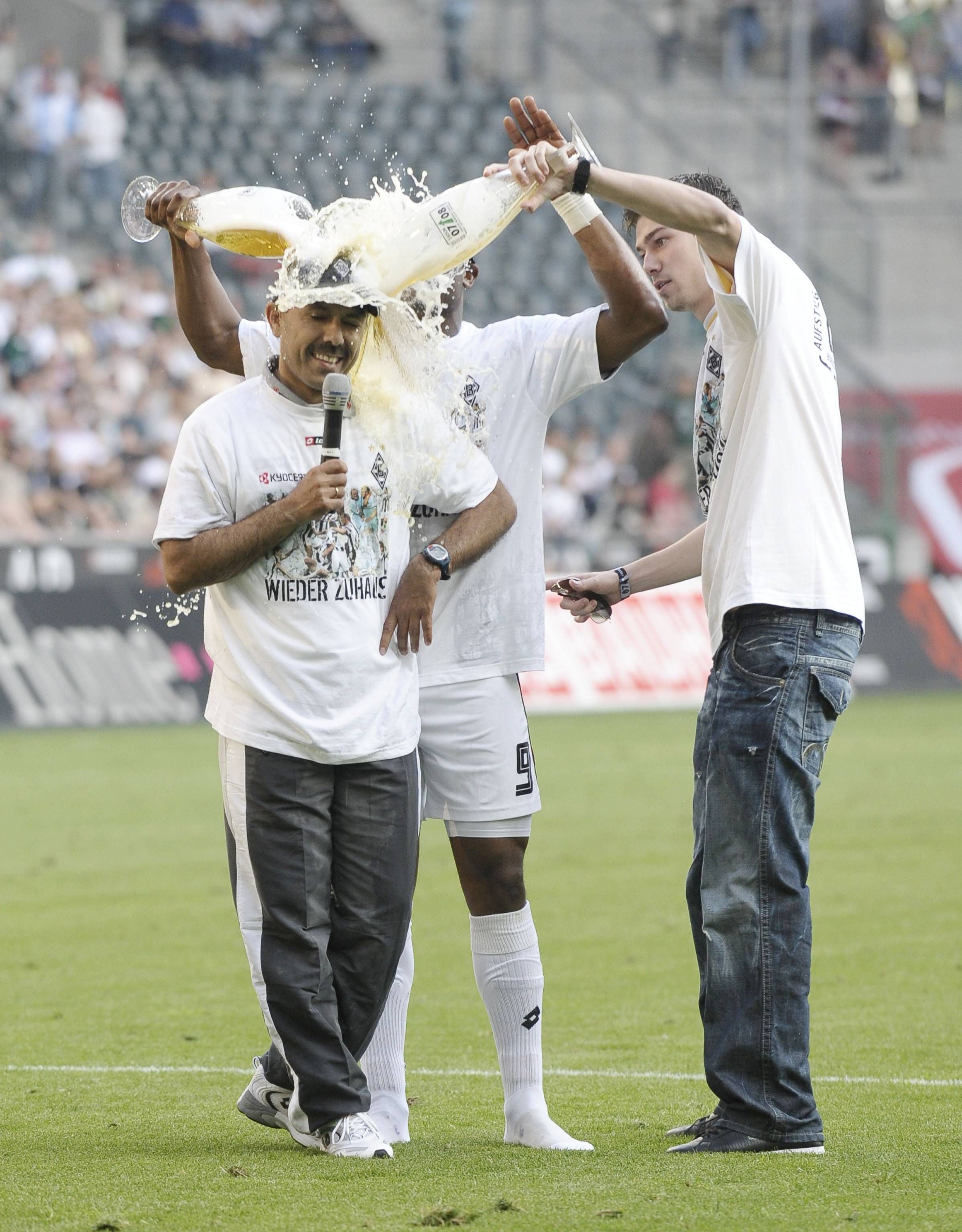 Borussia Mönchengladbach jubelt am 7. Mai 2008 über die Rückkehr in die Fußball-Bundesliga - und Aufstiegstrainer Jos Luhukay (l.) bekommt von seinen Spielern eine Bierdusche verpasst. Sebastian Schachten (r.) schüttet Luhukay Bier über den Kopf.
