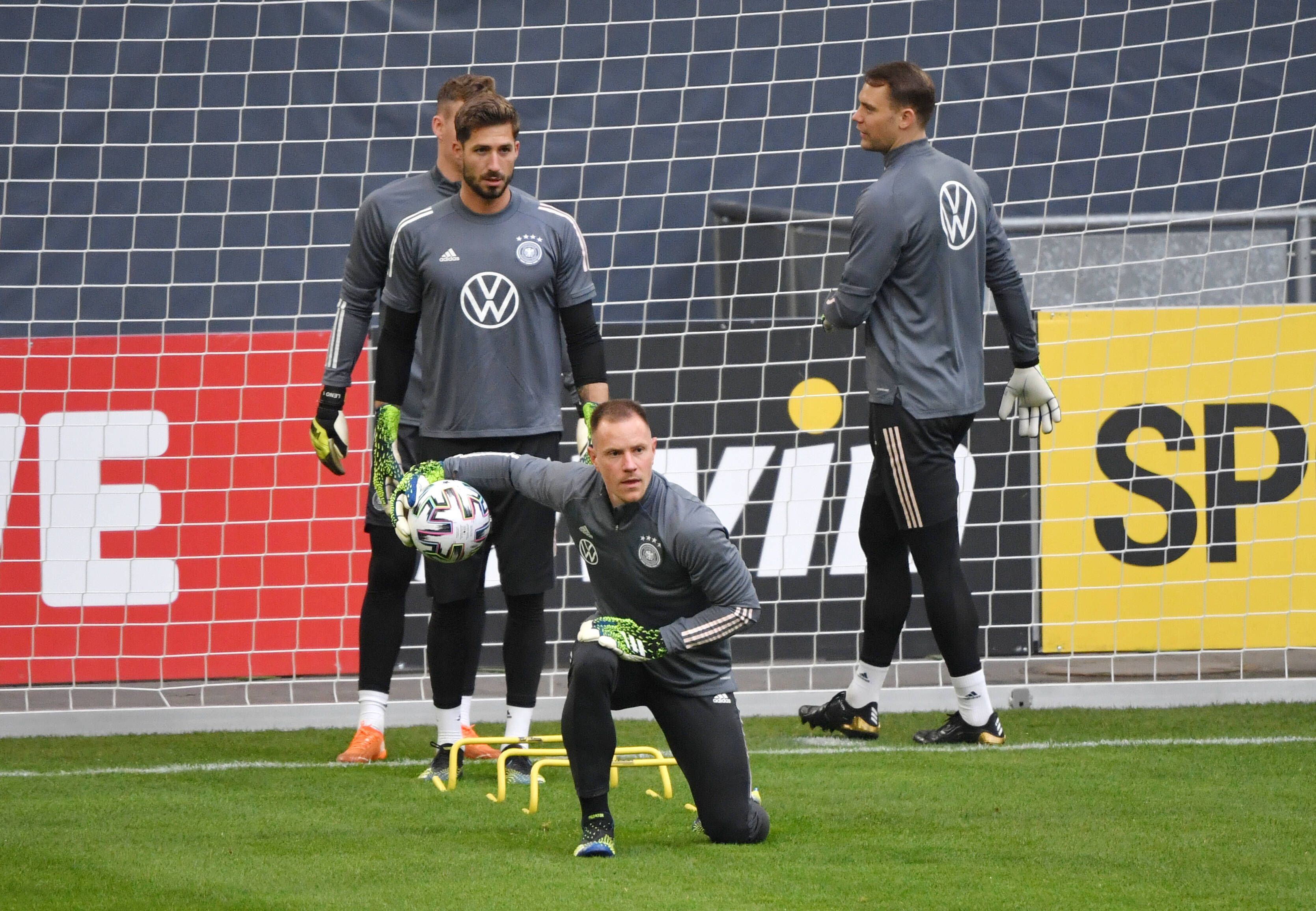 DFB-Torwart und Ex-Gladbach-Profi Marc-André ter Stegen (M.), hinter ihm sind auch Kevin Trapp und Manuel Neuer (r.) zu sehen. Das Foto ist am 23. März 2021 entstanden. Ter Stegen kniet und hat den Ball in einer Hand.