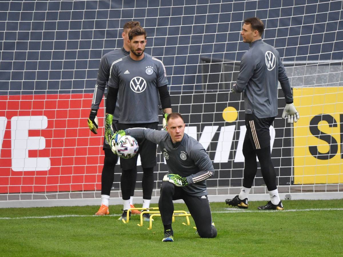 DFB-Torwart und Ex-Gladbach-Profi Marc-André ter Stegen (M.), hinter ihm sind auch Kevin Trapp und Manuel Neuer (r.) zu sehen. Das Foto ist am 23. März 2021 entstanden. Ter Stegen kniet und hat den Ball in einer Hand.
