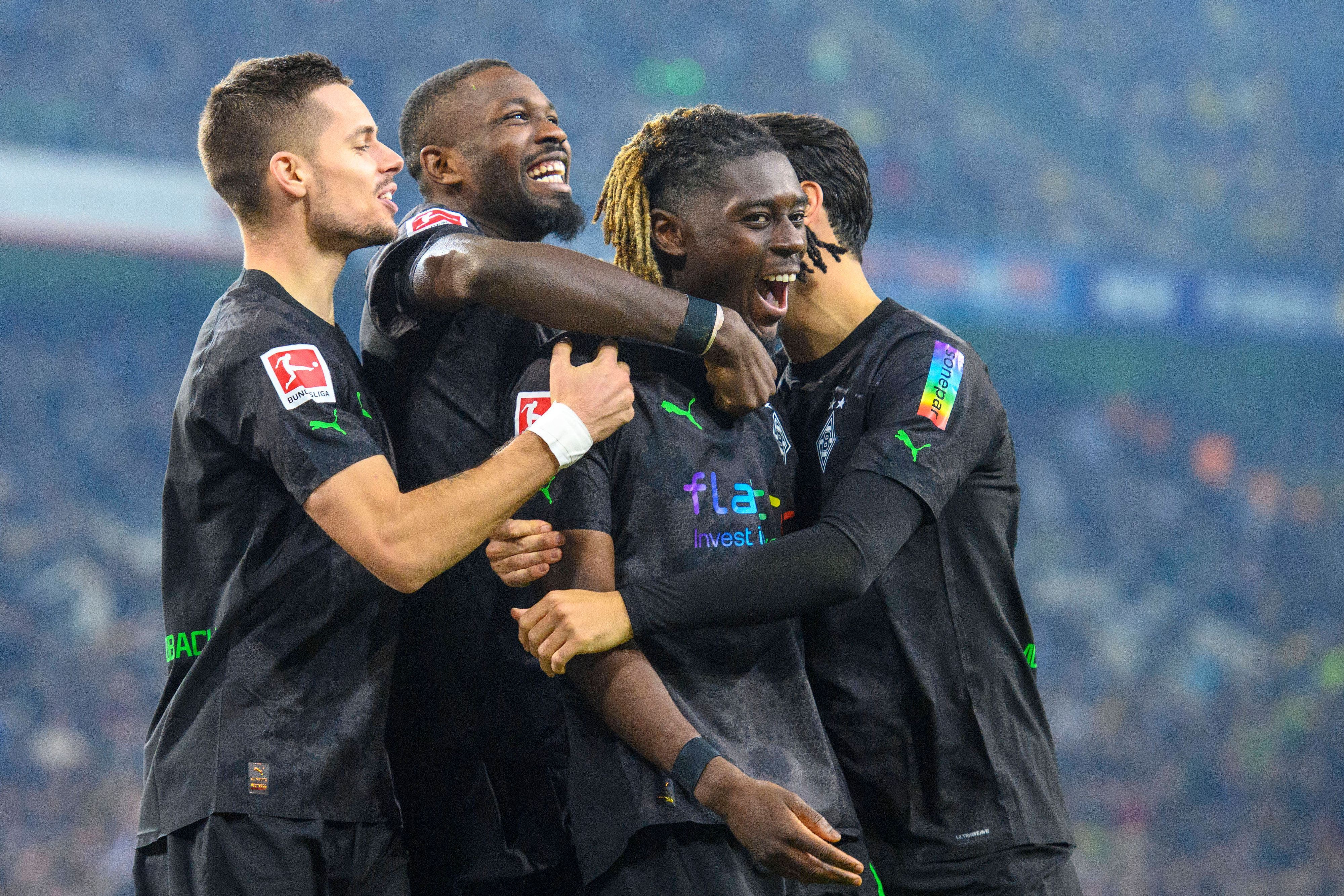 Der Gladbach-Profi Marcus Thuram (2.v.l.) jubelt gemeinsam mit Manu Koné (2.v.r.), Lars Stindl (r.) und Julian Weigl (l.) über einen Treffer. Hier zu sehen am 11. November 2022 im Borussia-Park während des Duells gegen Dortmund. Die Spieler umarmen sich.