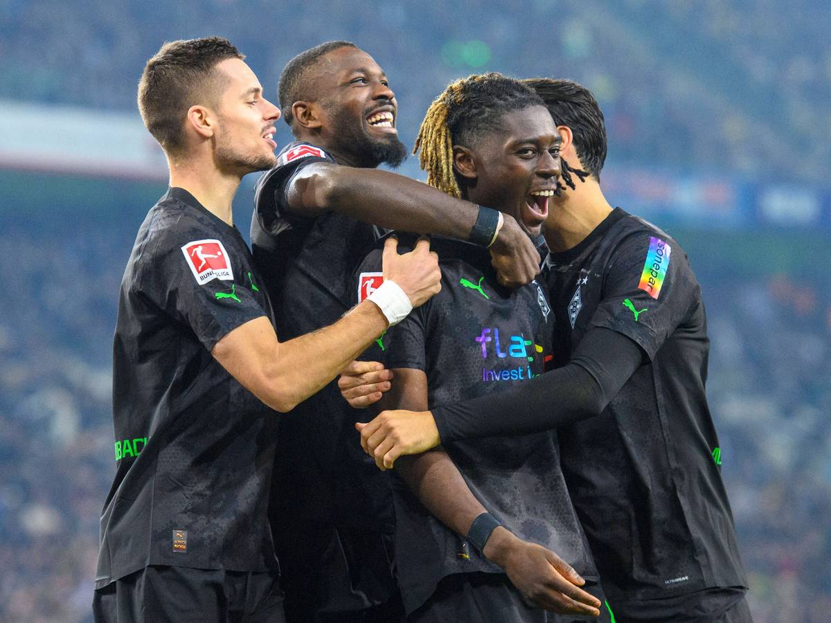 Der Gladbach-Profi Marcus Thuram (2.v.l.) jubelt gemeinsam mit Manu Koné (2.v.r.), Lars Stindl (r.) und Julian Weigl (l.) über einen Treffer. Hier zu sehen am 11. November 2022 im Borussia-Park während des Duells gegen Dortmund. Die Spieler umarmen sich.