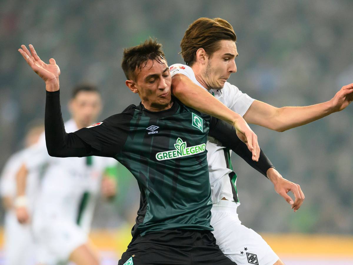 Gladbach-Profi Florian Neuhaus (r.) im Zweikampf mit Fabio Chiarodia (l.) von Werder Bremen. Das Foto stammt vom 17. März 2023. Die beiden haben den Blick auf den Ball gerichtet.