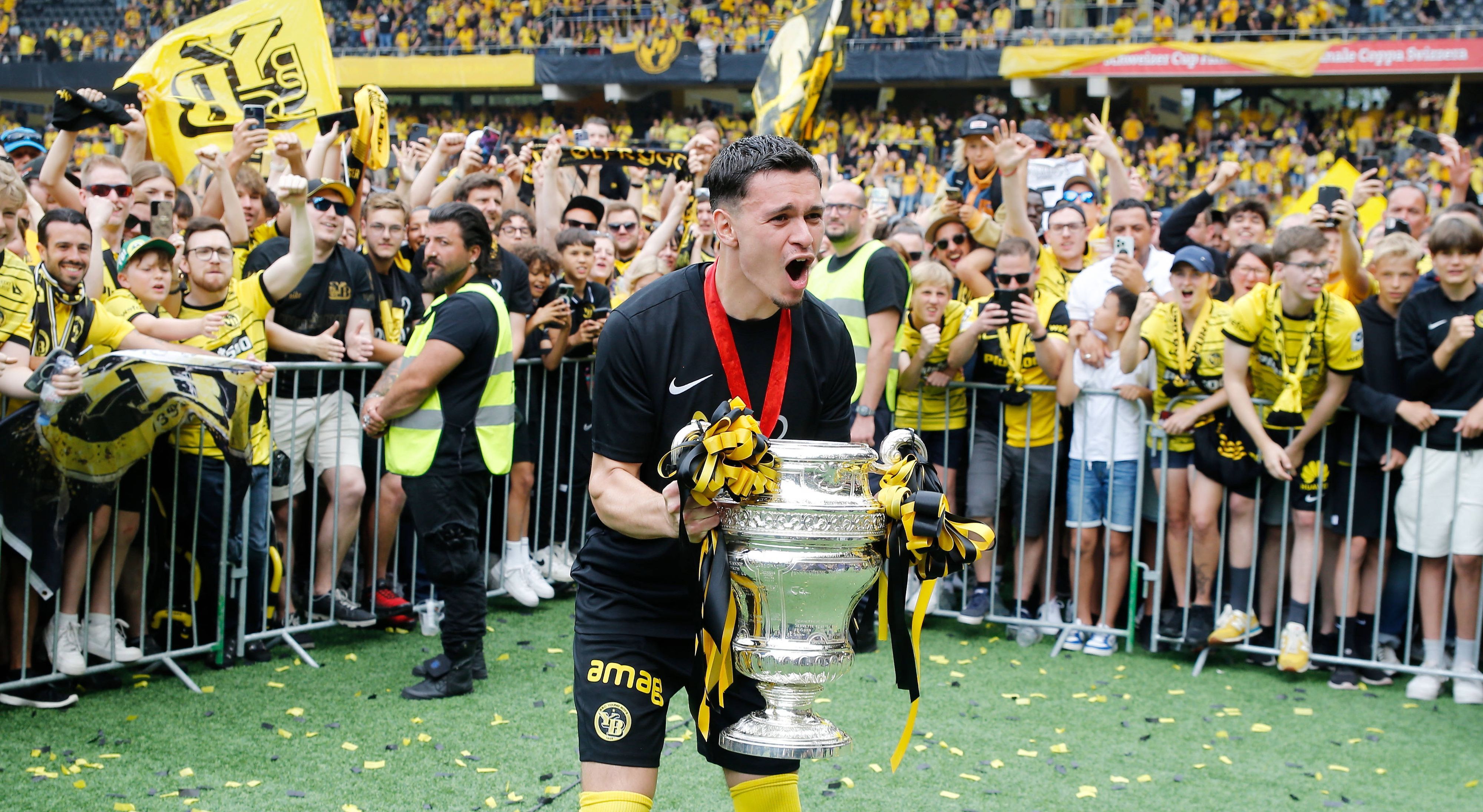 Da ist das Ding! Fabian Rieder von Young Boys Bern, hier zu sehem am 4. Juni 2023 in Wankdorf, feiert mit den Fans den Pokalgewinn. Rieder hält den Pokal in seinen Händen und schreit seine Freude heraus.