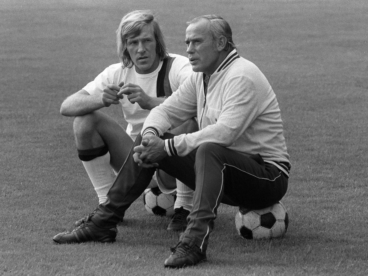 Hennes Weisweiler (r.), Trainer-Legende von Borussia Mönchengladbach, im Gespräch mit seinem Spielmacher Günter Netzer (l.). Dieses Foto zeigt die beiden am 25. Juli 1971. Die beiden sitzen jeweils auf einem Fußball.