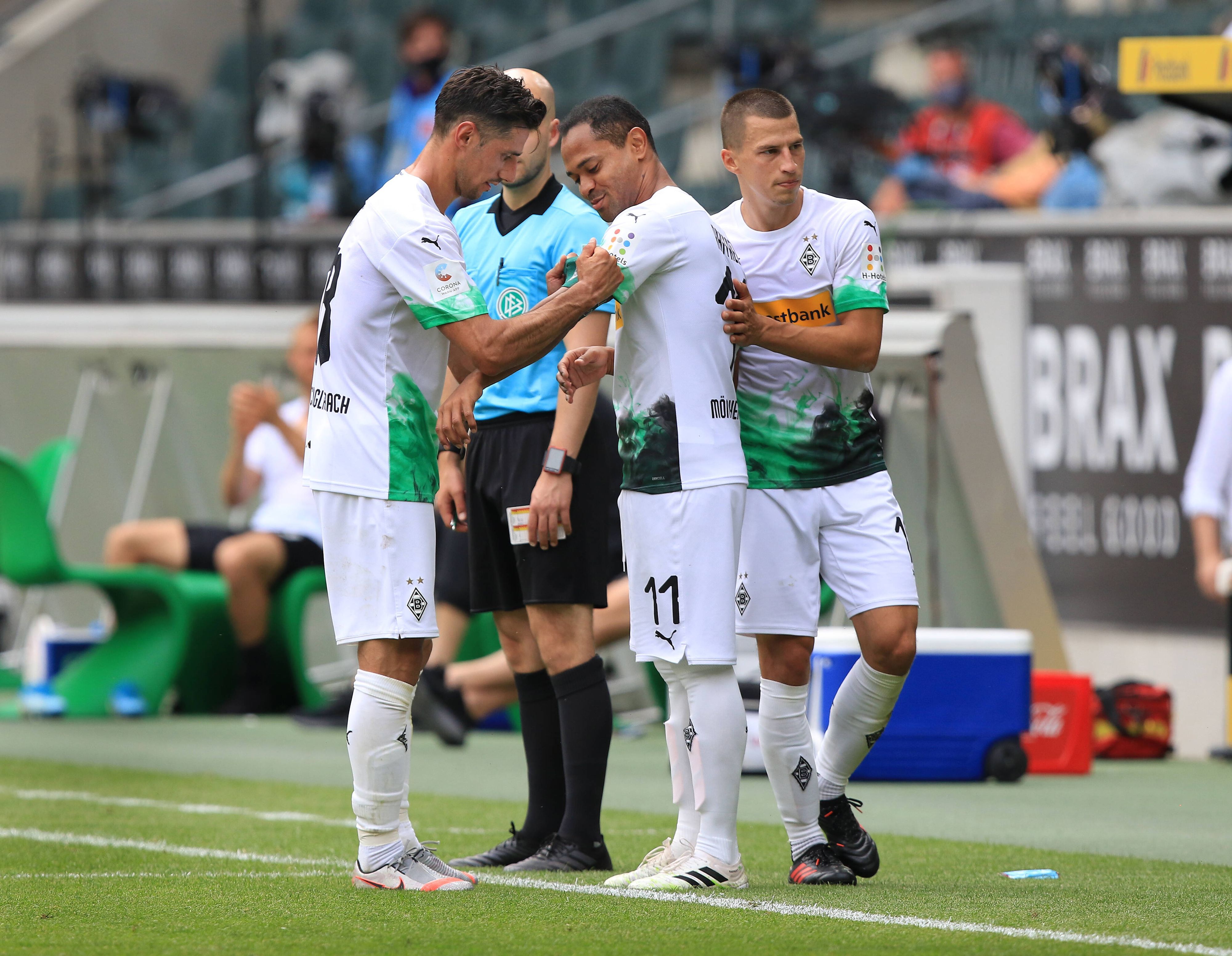Lars Stindl (l.) überreicht Raffael (M.) in dessen letztem Spiel für Borussia Mönchengladbach gegen Hertha BSC am 27. Juni 2020 die Kapitänsbinde.