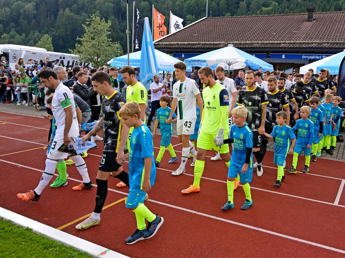 Auch in dieser Sommervorbereitung trägt Borussia Mönchengladbach wieder ein Testspiel auf dem Sportplatz Birkenmoos in Rottach-Egern aus. Das Foto stammt vom letztjährigen Test gegen 1860 München am 10. Juli 2022. Die Teams laufen vor dem Spiel auf das Feld.