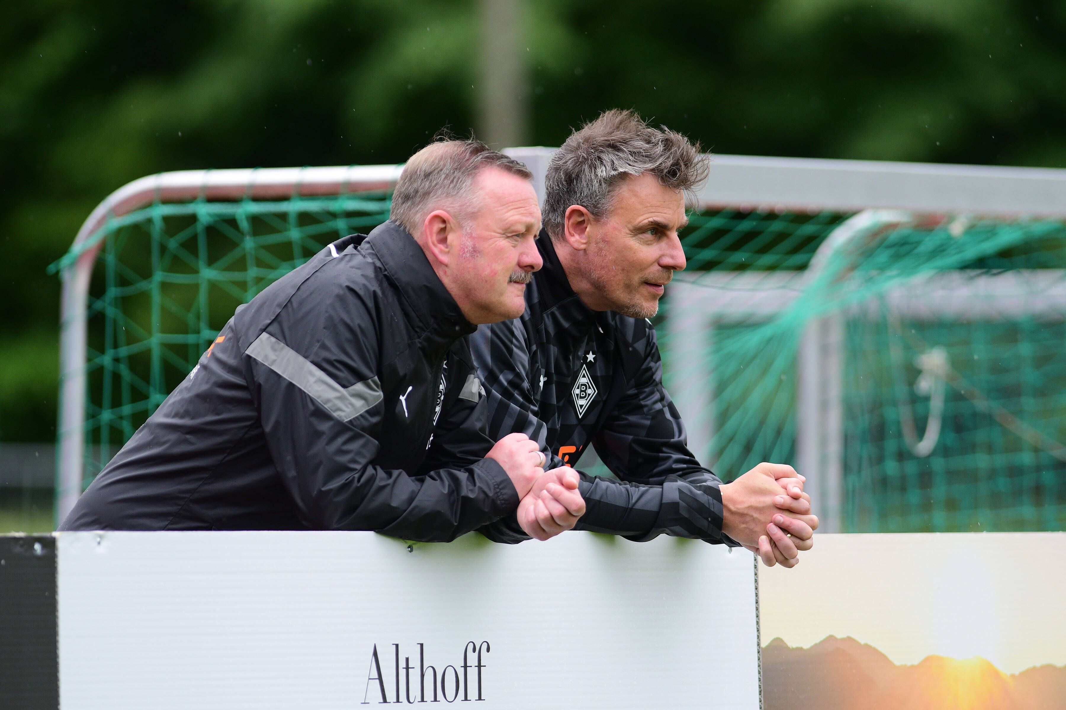 Roland Virkus (l.) und Steffen Korell stehen im Trainingslager von Borussia Mönchengladbach am 4. Juli 2022 am Spielfeldrand.