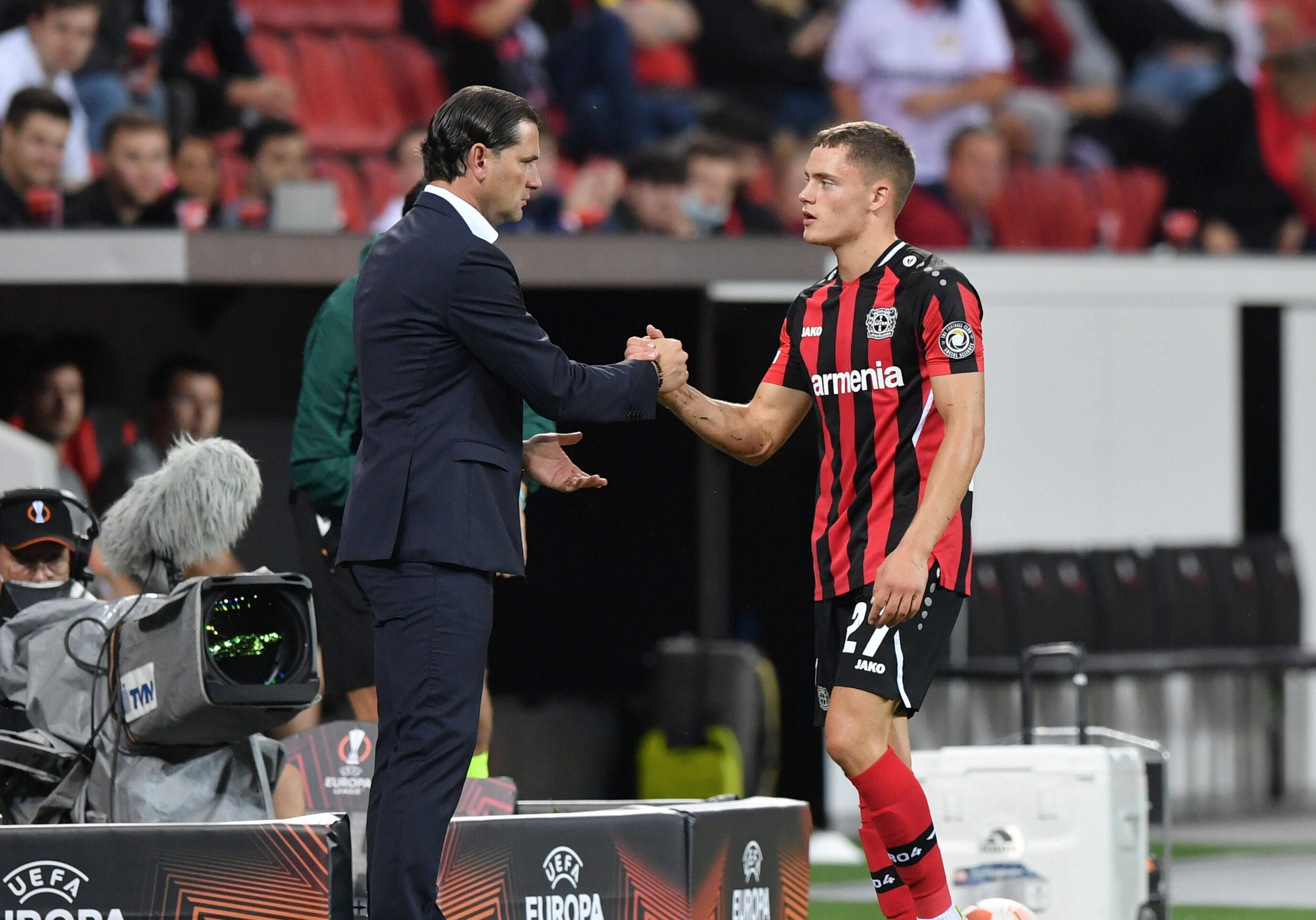 Gerardo Seoane (l.) gibt Florian Wirtz im Rahmen eines Spiels von Bayer Leverkusen am 16. September 2021 die Hand.