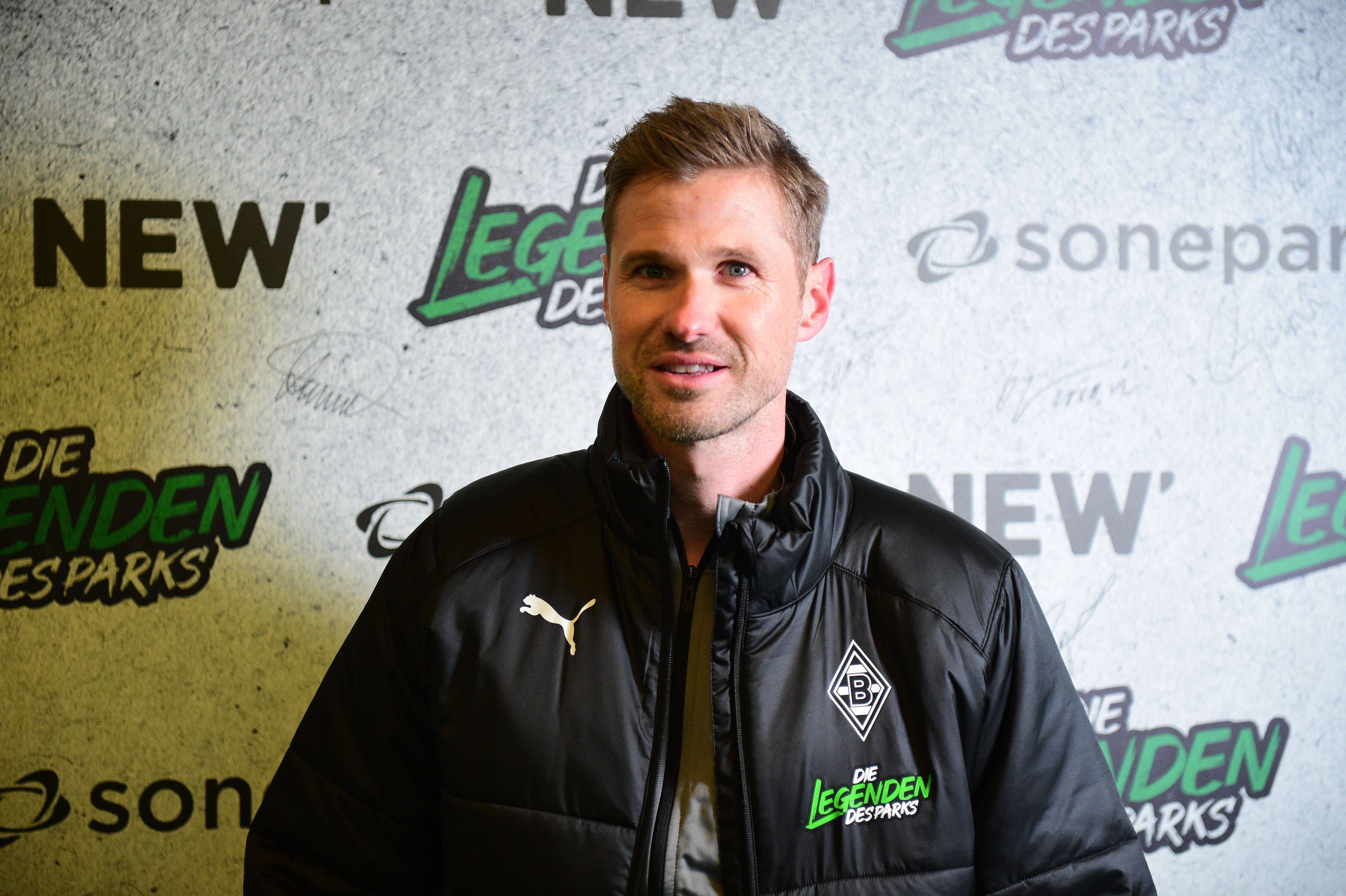 Oliver Kirch, hier am 17. Dezember 2022 im Borussia-Park zu sehen, ist der neue U19-Trainer bei Fußball-Bundesligist Borussia Mönchengladbach. Kirch steht vor einer Fotowand, auf der Legenden des Parks zu lesen ist.