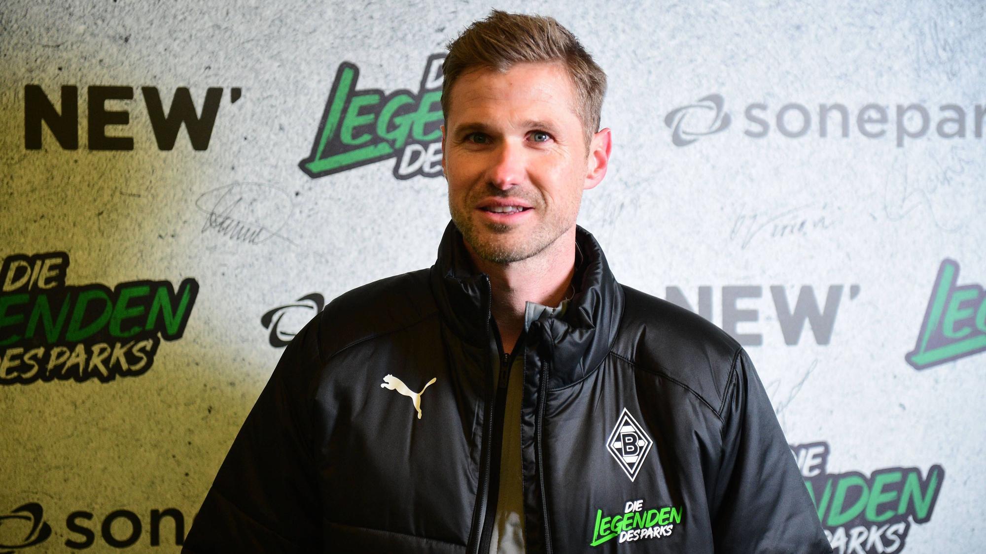 Oliver Kirch, hier am 17. Dezember 2022 im Borussia-Park zu sehen, übernimmt den U19-Trainerjob bei Fußball-Bundesligist Borussia Mönchengladbach. Kirch steht vor einer Fotowand, auf der Legenden des Parks zu lesen ist.